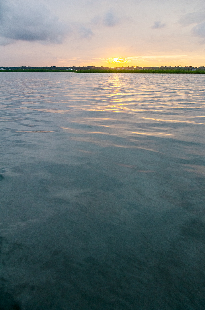 Watching the textures of the coastal water play with the light of a soft yellow sunset