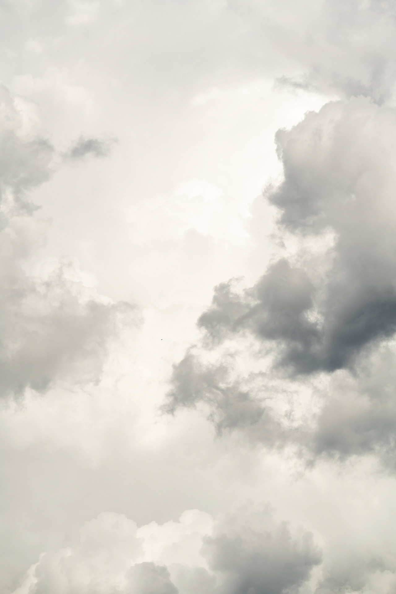 parting dark grey clouds make a path upwards towards brilliantly white clouds