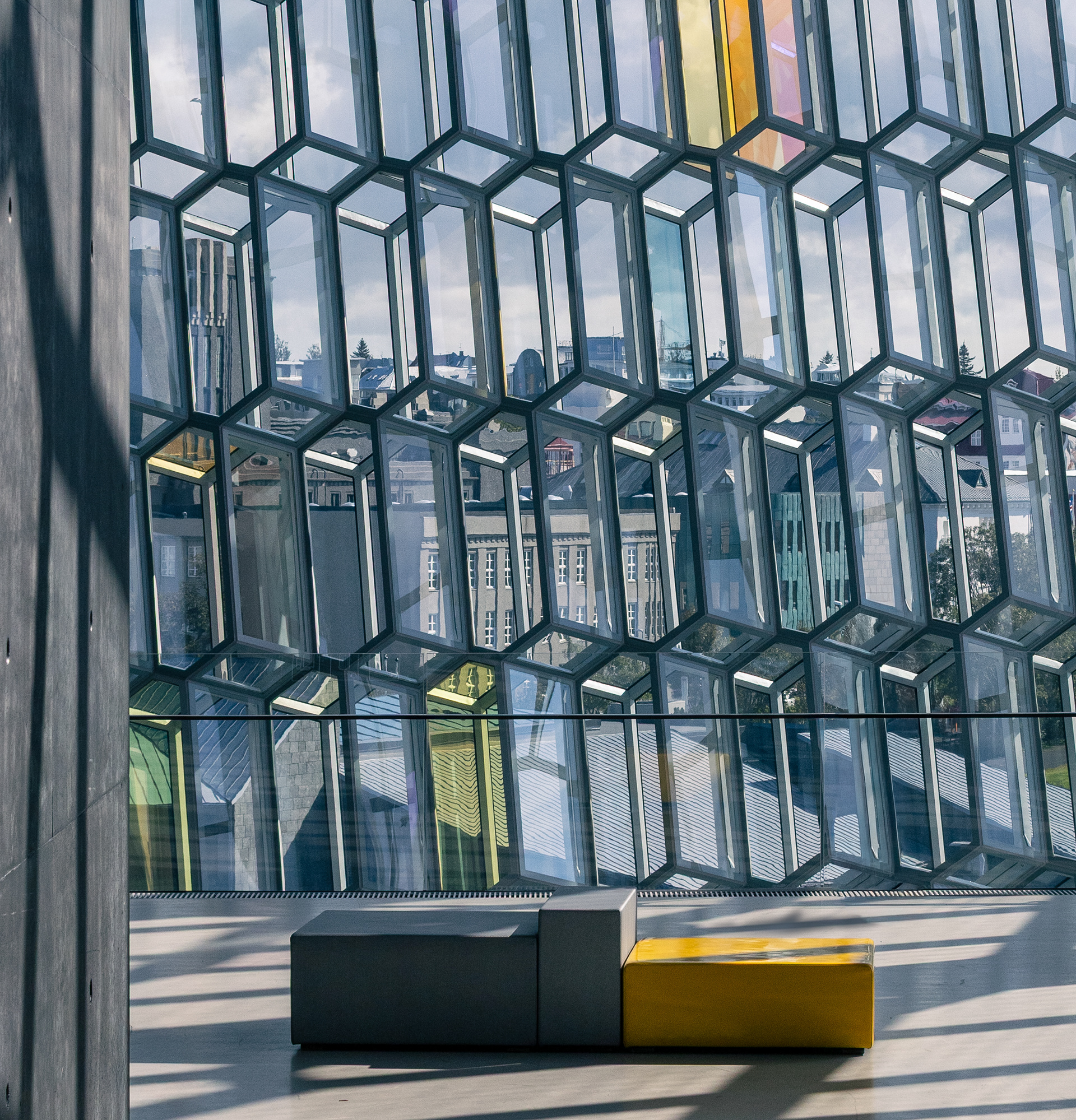 Interior glass facade detail at Harpa Concert Hall in Reykjavik Iceland with geometric honeycomb windows and city reflections