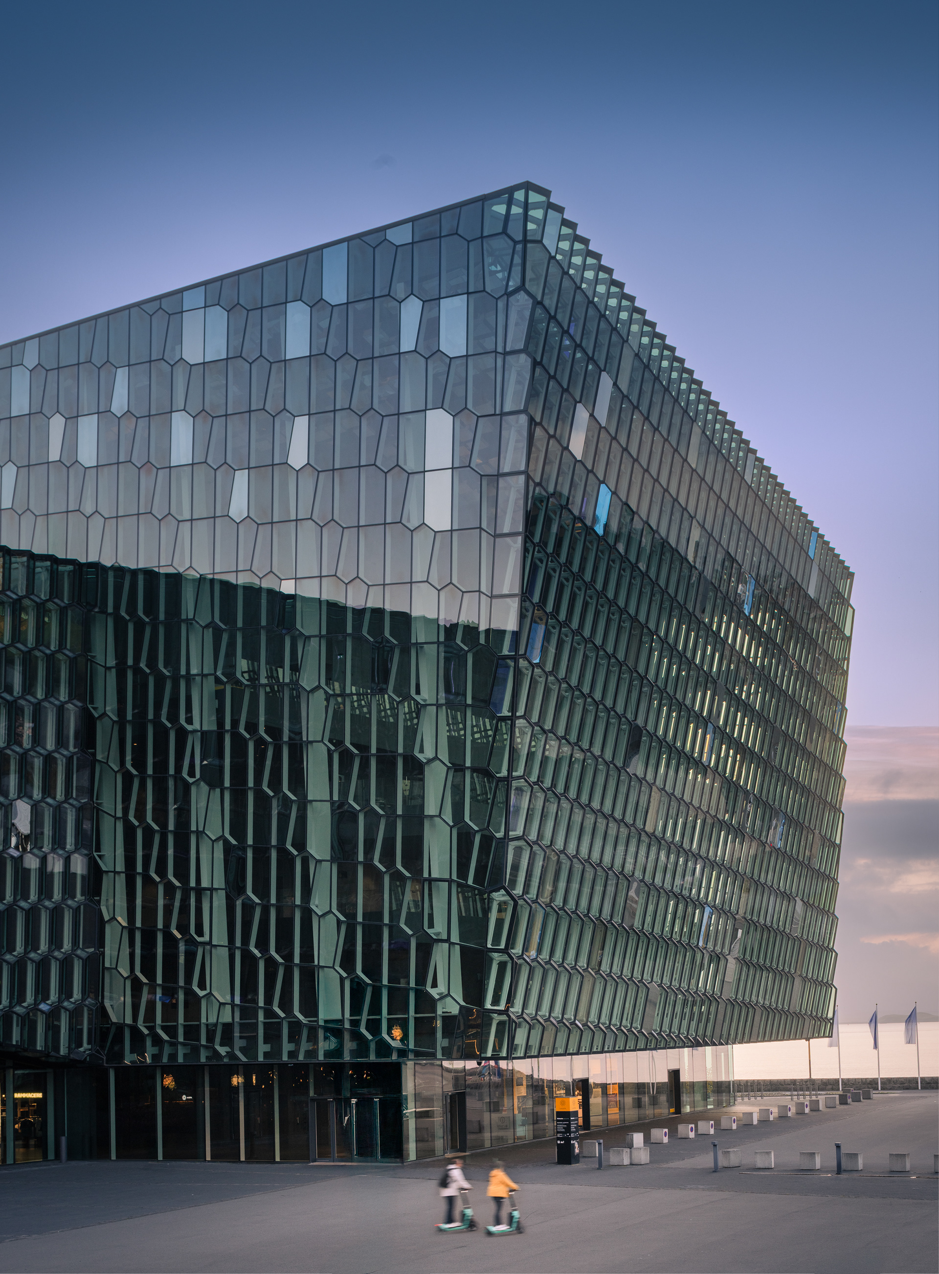 Exterior view of the geometric glass facade of the Harpa Concert Hall in Reykjavík Iceland with hexagonal panels facing the harbor.