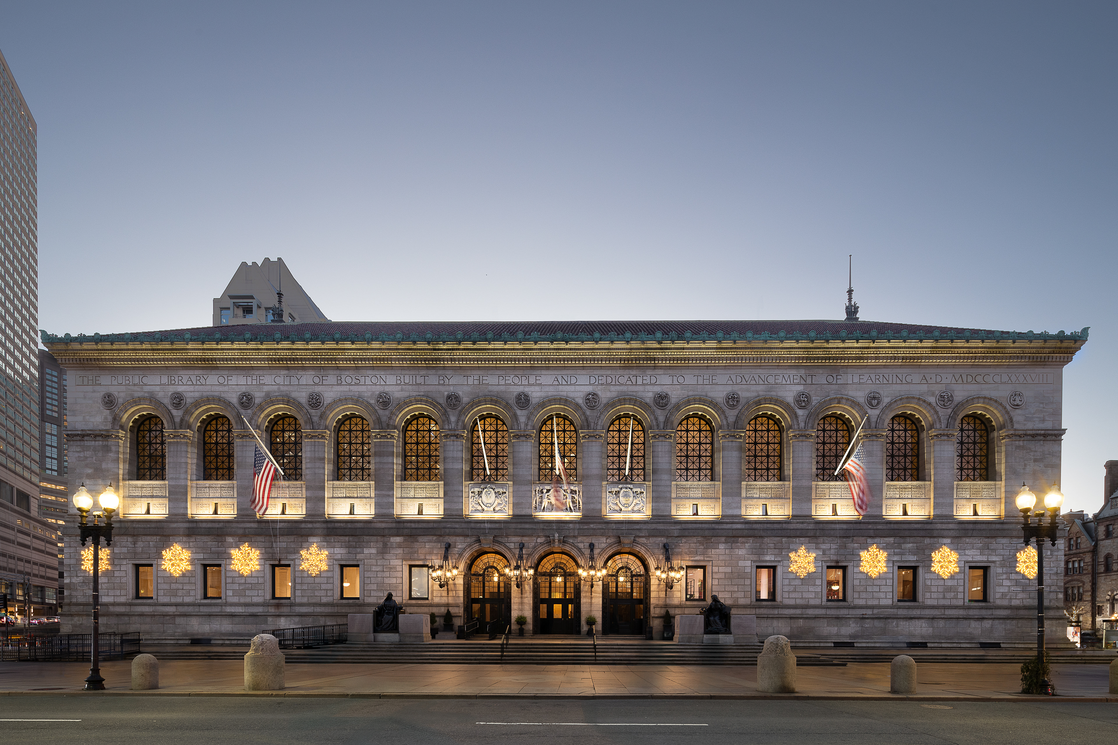 Boston Public Library McKim Building illuminated at twilight in Copley Square Boston Massachusetts.