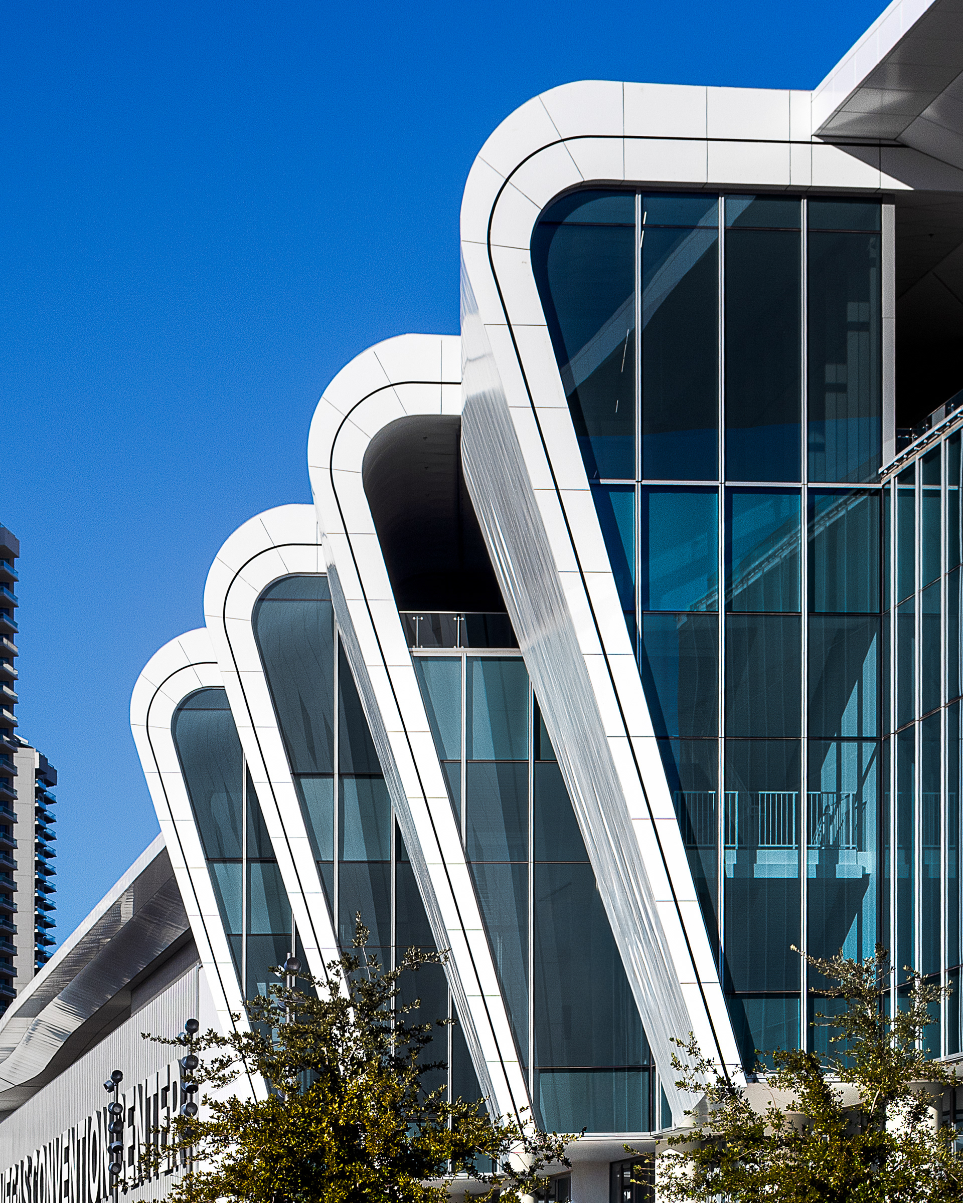 Close-up of the West Hall’s curved white ribbon facade.