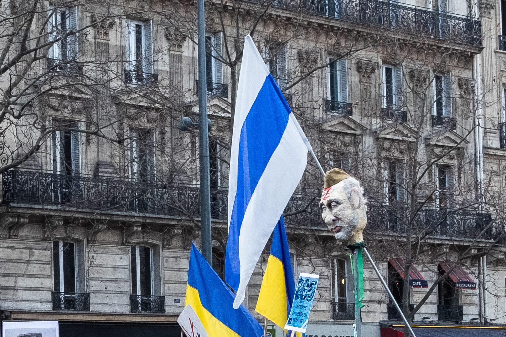 Le drapeau blanc-bleu-blanc flottant au bout d’une pique au-dessus de la tête de Vladimir Poutine en papier mâché symbolise la Russie opposée à la guerre contre l’Ukraine.