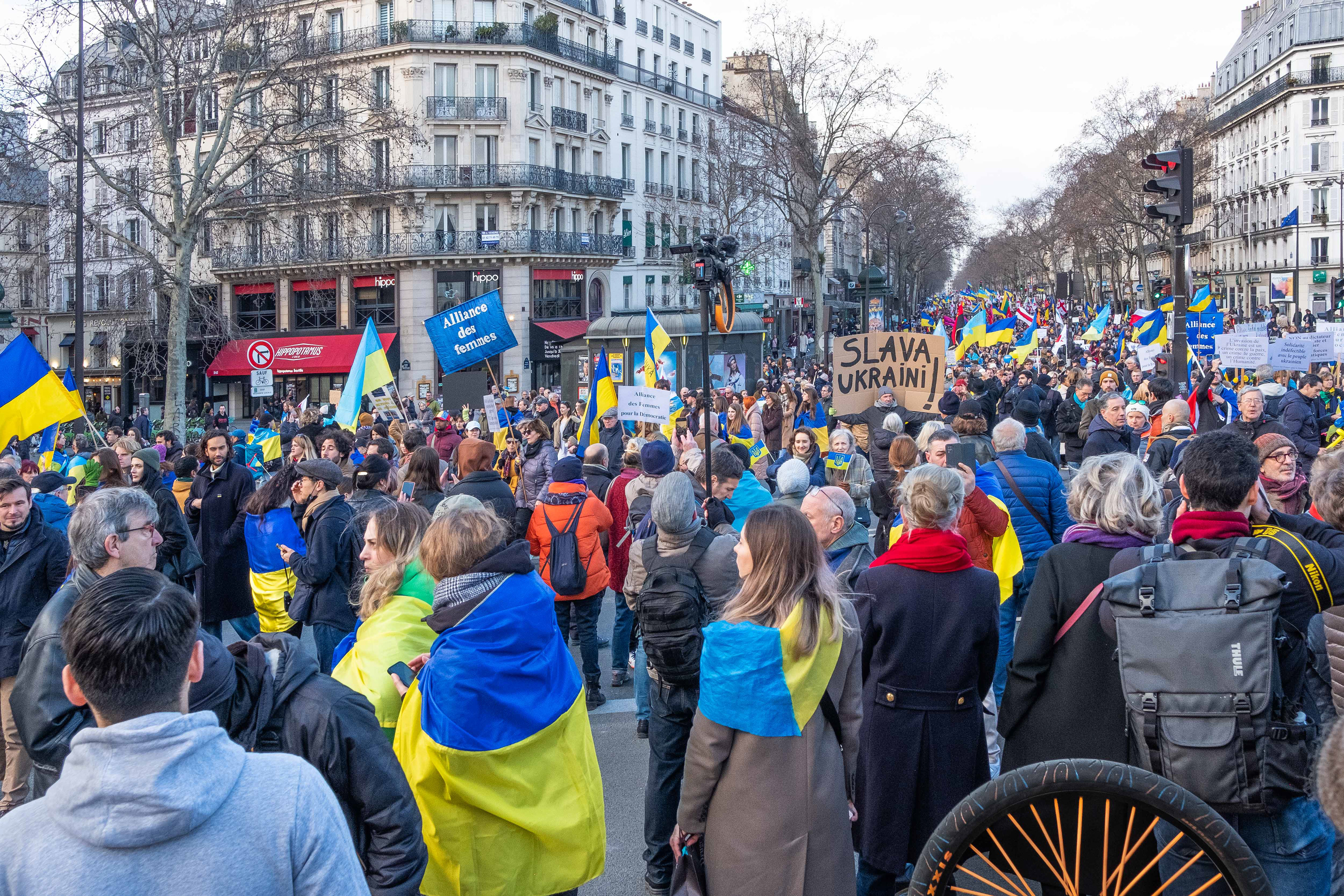 Le cortège arrive place de la Bastille. Sur la pancarte en carton brut, "Slava Ukraïni" signifie "Gloire à l'Ukraine".