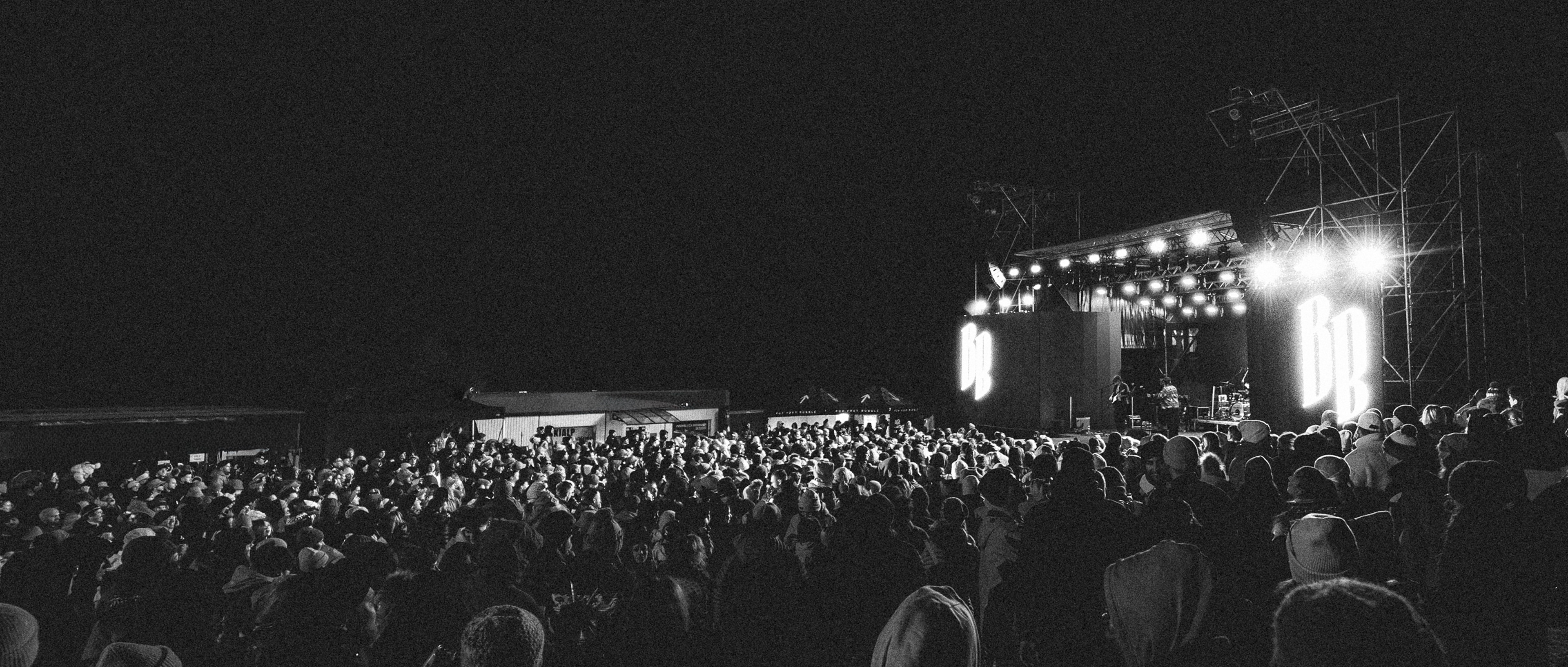 Epic black and white concert photography of band Billy Barman live at Winter Grape festival, massive crowd and stage lights / Epická čiernobiela koncertná fotografia kapely Billy Barman naživo na festivale Zimný Grape, masívny dav a svetlá pódia.