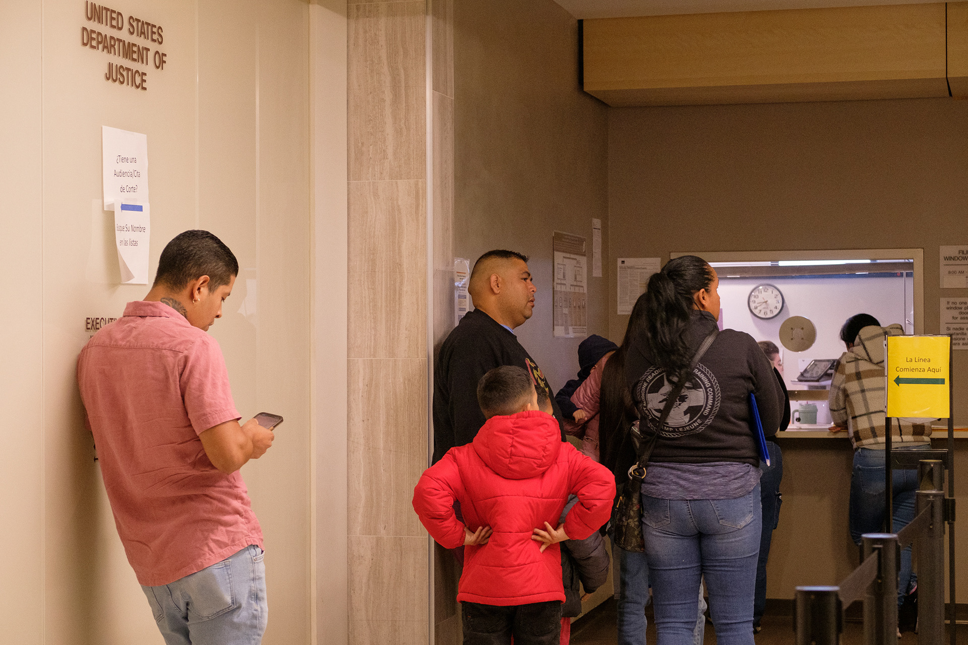 People wait in line for processing Thursday, Oct. 24, 2024, at the Byron Rogers Federal Building in the downtown Denver Federal District. Signs are posted in both English and Spanish, as many people going through the Denver Immigration Court are originally from Spanish-speaking countries. (Claudia A. Garcia, Special to The Colorado Sun)