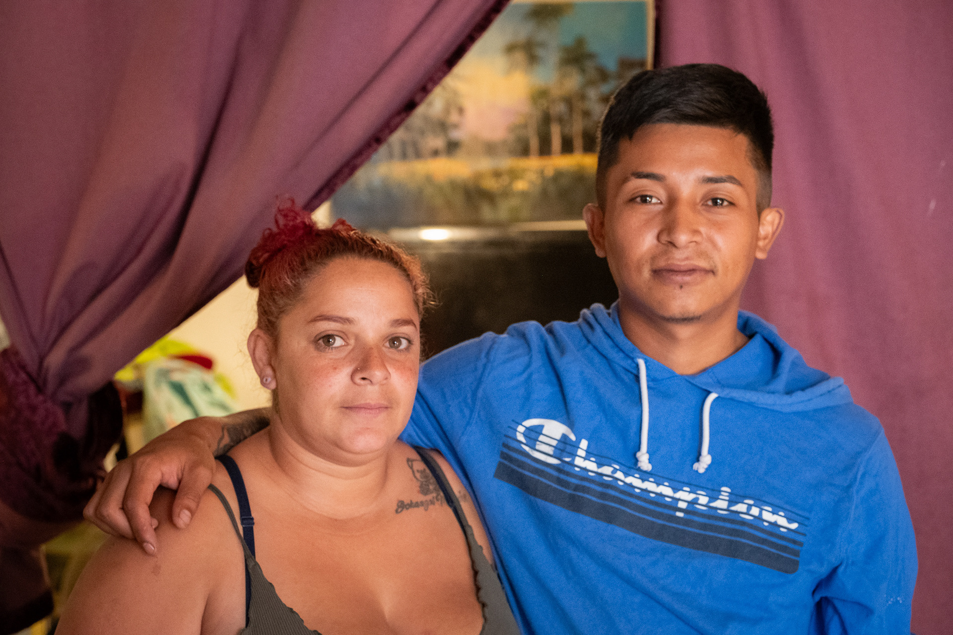 Francy Rodriguez and her husband Anthony Brabo pose in their living room at an apartment complex in Aurora. When they moved into the apartment in January, management assured them that repairs would begin within a week – as of September, no repairs have been made to their apartment, they said. (Claudia A. Garcia, Special to The Colorado Sun)