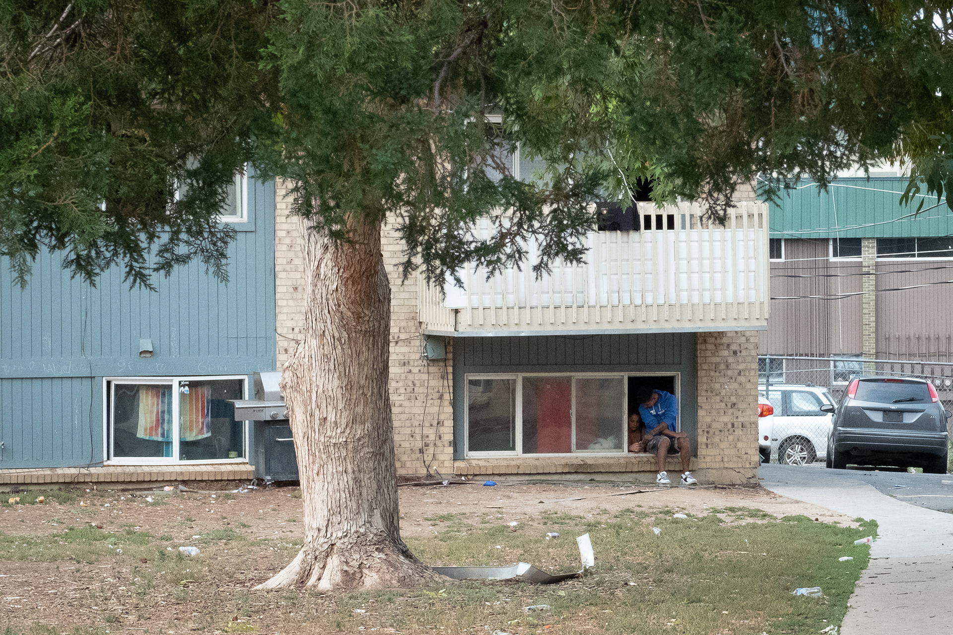 Anthony Brabo and his wife Francy Rodriguez sit by the window at an apartment complex in Aurora. Their A/C and their heating has not worked since they moved in January, so they don’t understand why their monthly Xcel energy bill is so high – in August their Xcel bill was $195.06. (Claudia A. Garcia, Special to The Colorado Sun)