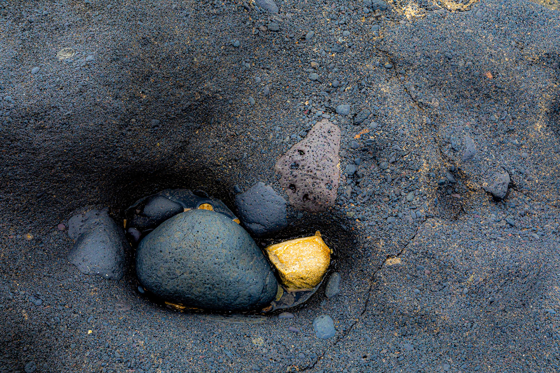Gold? Aufgenommen an einem Strand auf Fuerteventrua. Der Sandstein glänzt wie Gold unter den Lavakieseln.