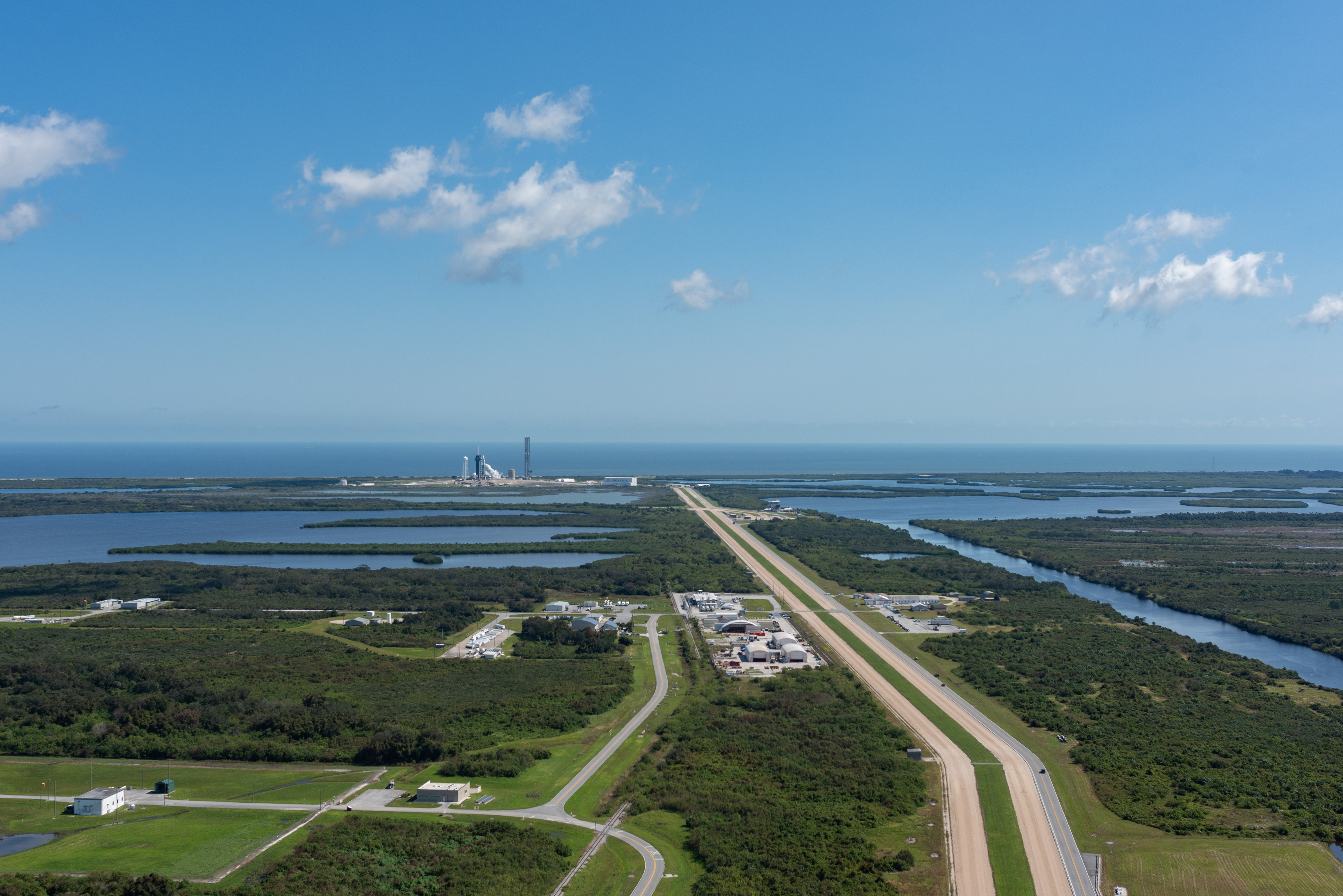 View of Launch Complex 39A (left with tower) from the roof of NASA's Vehicle Assembly Building ahead of liftoff of SpaceX's Falcon Heavy launching the Europa Clipper mission. Credit: Brandon Moser/Central Florida Public Media
