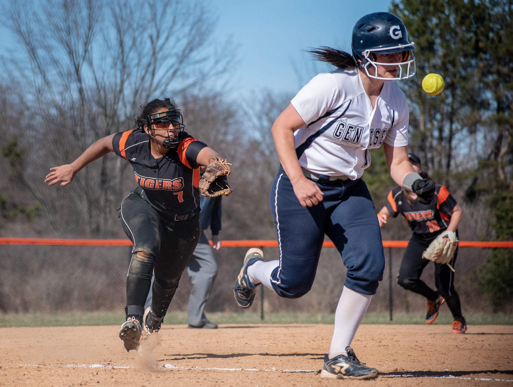 Sophomore Raquel Estrada of RIT, goes to make a catch at 3rd base as Senior Taylor Fedor of SUNY Geneseo makes a run for the home plate at the RIT Softball Field in Henrietta NY during the game on April 17th, 2019. SUNY Geneseo won 3-1