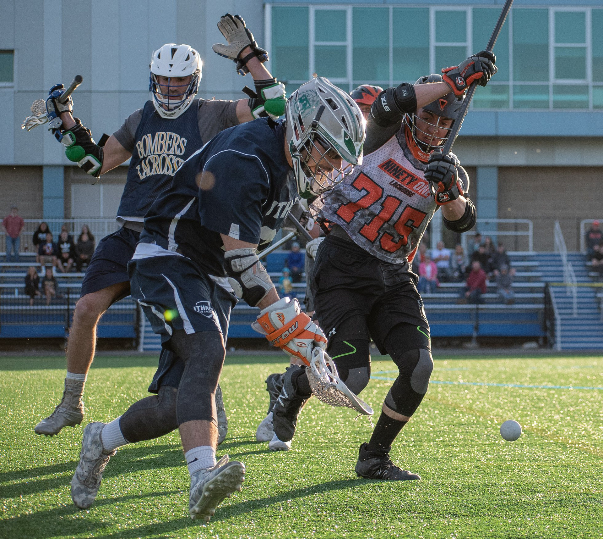 Stratton Drivanos of Ithaca goes for a ground ball against Steven Ketelsen of RIT, as Ithaca's Jack Cody backs off from Ketelsen's stick check during the Ithaca and RIT Club Lacrosse game at the Higgins Stadium in Ithaca NY on April 14th, 2019. Ithaca won 6-5.