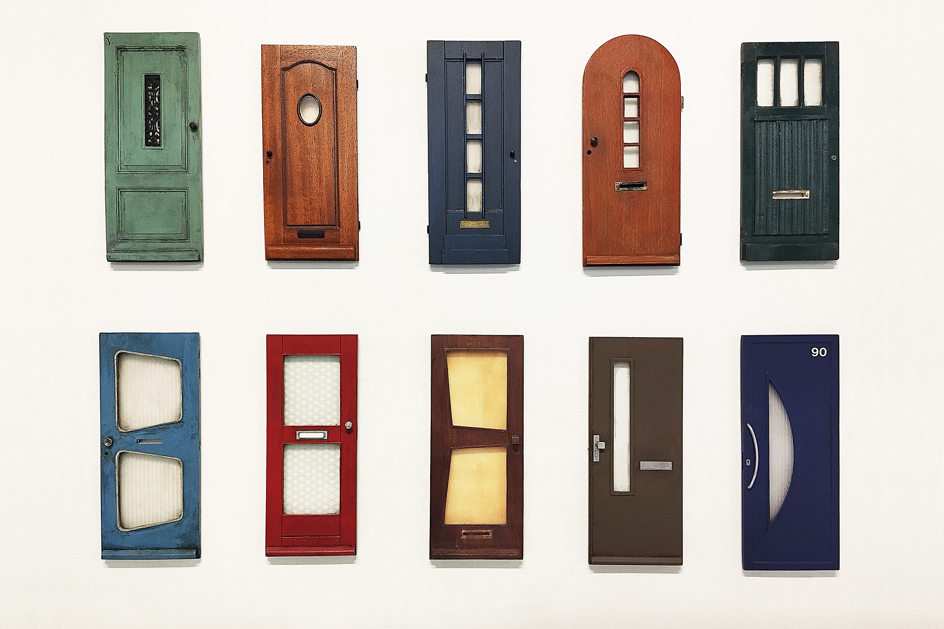 Doors of Perception, 2024, serie van 10 deuren die elk een decennium van de 20ste eeuw verbeelden, diverse materialen, gem. afm.. H. 27 - B. 11 - D. 1 cm.