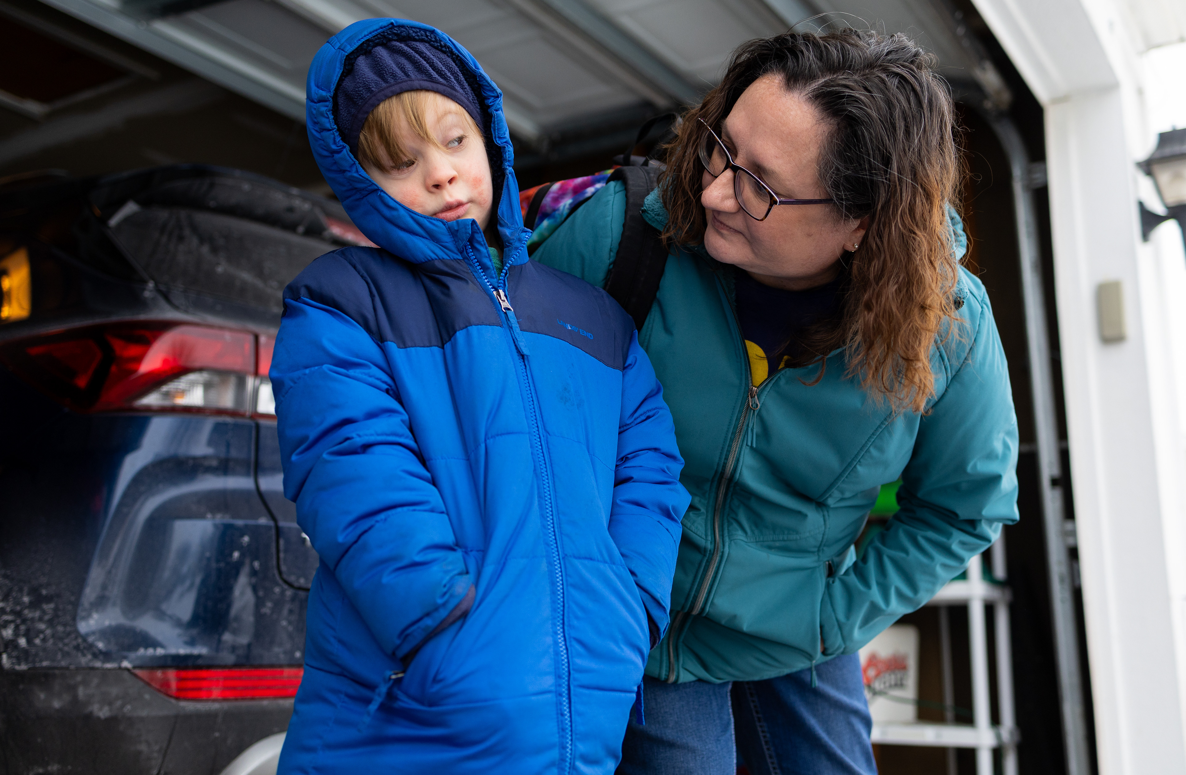 Trevor Woodrum, 8, eyes his mother Kimberly Steffes as she asks him if he wants to sing “Take it to the Limit” by the Eagles while they waited for his bus to take him to school, Friday, Dec. 5, 2025, at their home in Joliet, Illinois. According to his dad Scott Woodrum, Trevor likes children’s music and the bands Journey and the Eagles. Steffes took to social media to condemn President Donald Trump for using the R-word in a Truth Social post. (Dominic Di Palermo/Chicago Tribune)