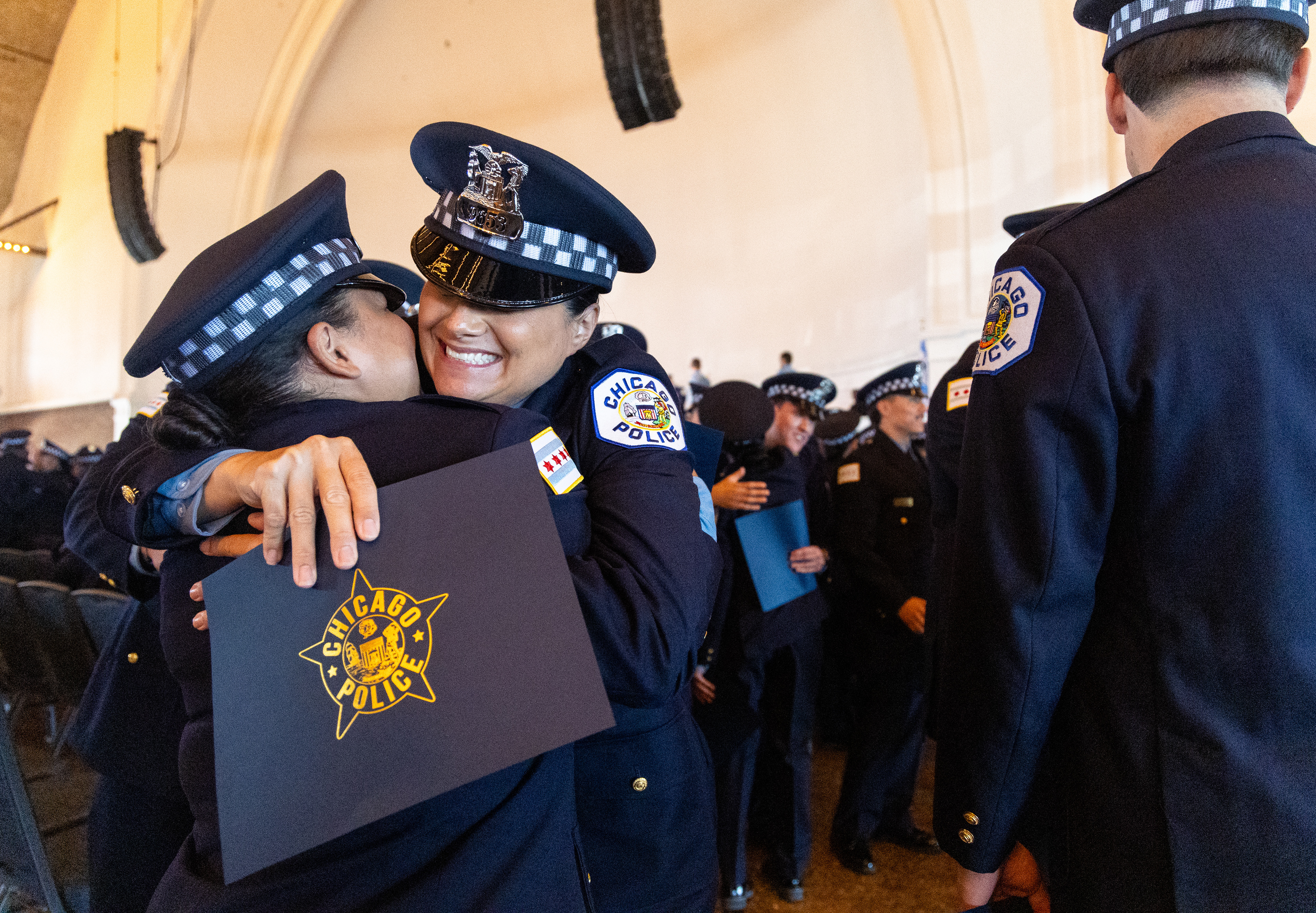 Chicago Police officers Francis Martillo and Detinee Reib embrace after their Graduation and Promotion Ceremony Tuesday, July 22, 2025 at Navy Pier in Chicago. The ceremony recognized graduates from three recruit classes as well as recently promoted captains, lieutenants, sergeants, detectives and field training officers. (Dominic Di Palermo/Chicago Tribune)