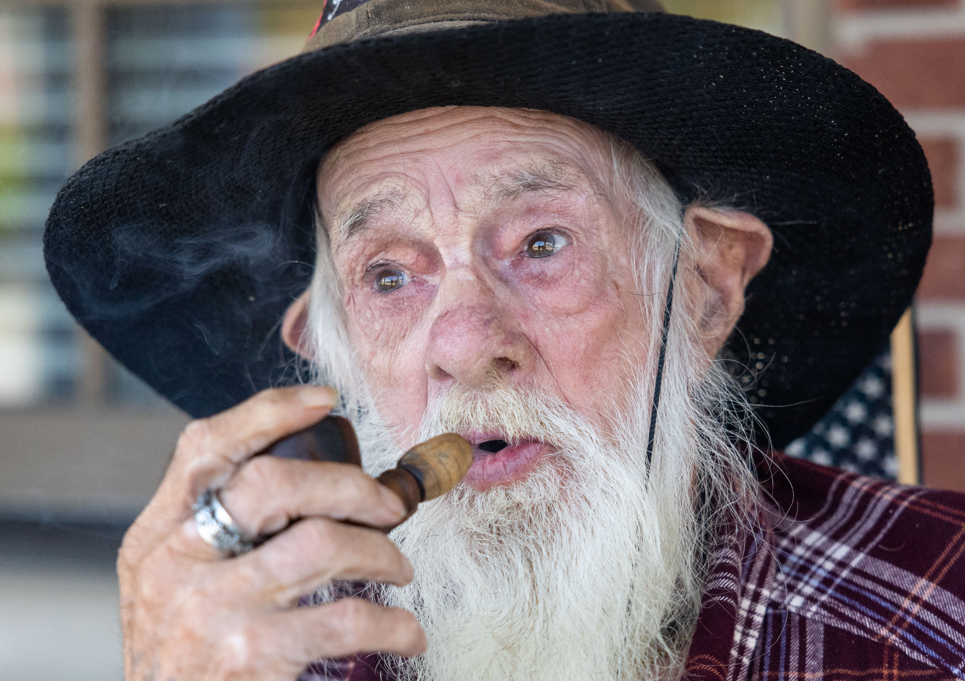B.J. “the pot smoking preacher” Leach, 82, lights his pipe filled with marijuana wile posing for a portrait on Williamsburg City Hall’s front porch in Williamsburg, Kentucky on Oct. 24, 2024. Leach is a proud medical marijuana card holder and often attributes its legality in Kentucky to his activism. A marijuana card in Kentucky does not permit the smoking of the substance, only ingestion.