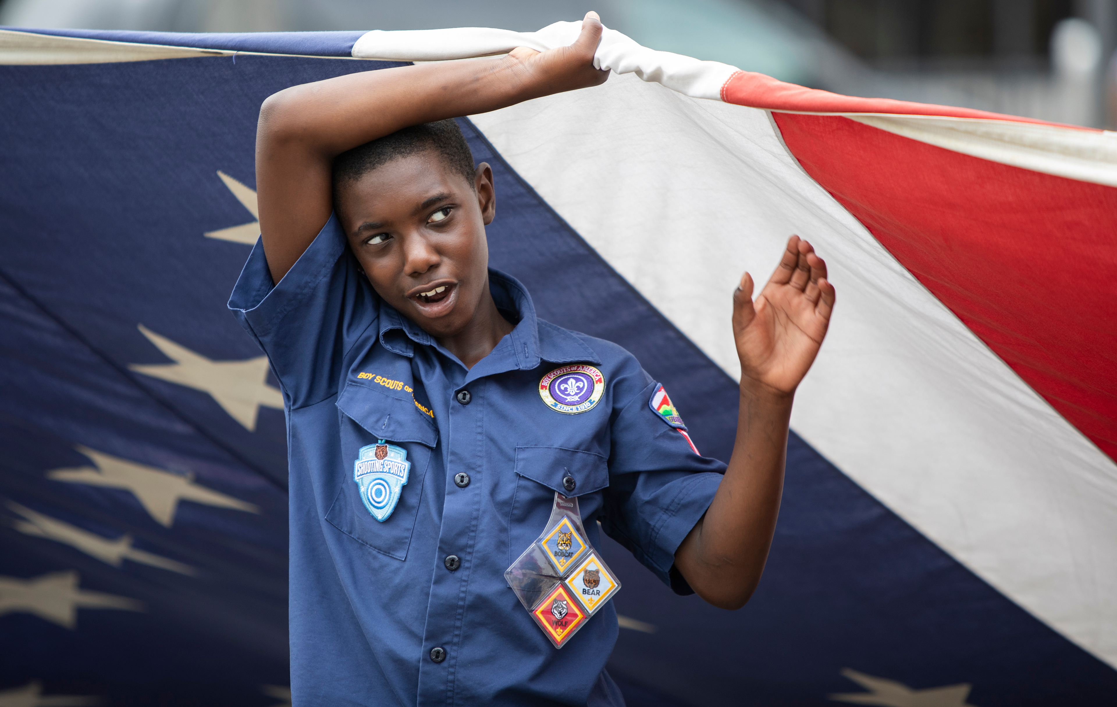 Scout Tristan Moore, 9, of Berkeley holds up a large American flag before the Annual Ferguson Fourth of July Parade on Florissant Rd. in Ferguson on Thursday, July 4, 2024. 