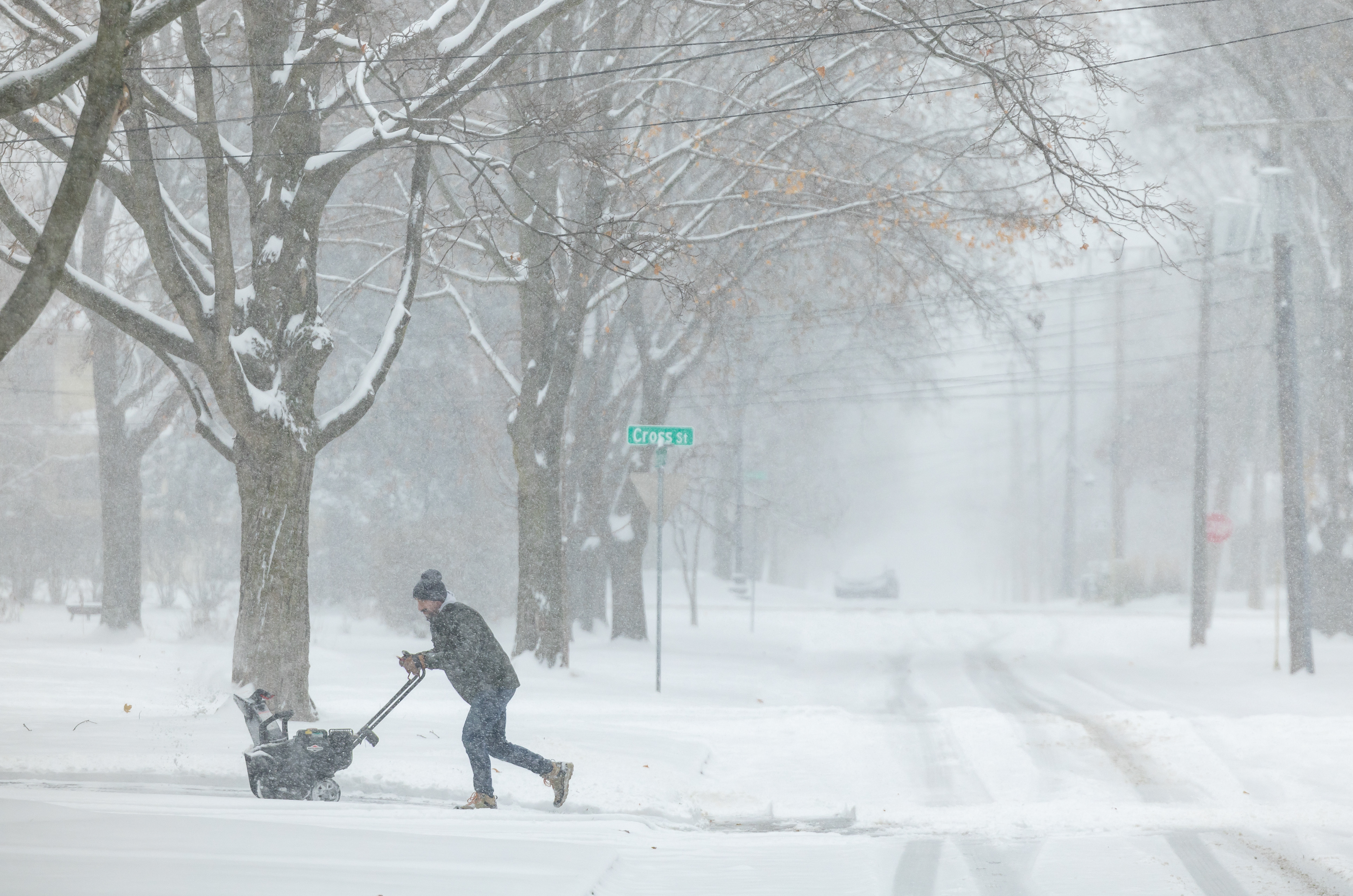 A person snow blows their driveway during a winter storm Saturday, Nov. 29, 2025, on East Madison Avenue in Wheaton, Illinois. Chicagoans and suburban residents experienced eight inches of snow over the weekend. (Dominic Di Palermo/Chicago Tribune)