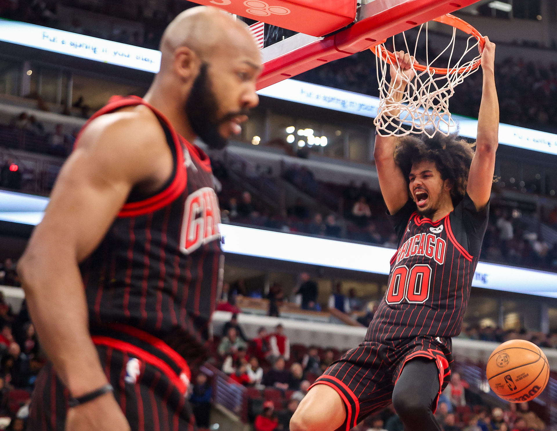 Chicago Bulls forward Trentyn Flowers (00) celebrates an alley-oop that was assisted by Chicago Bulls guard Jevon Carter (5) in the fourth quarter during a game against the Golden State Warriors, Sunday, Dec. 7, 2025, at the United Center in Chicago. (Dominic Di Palermo/Chicago Tribune)