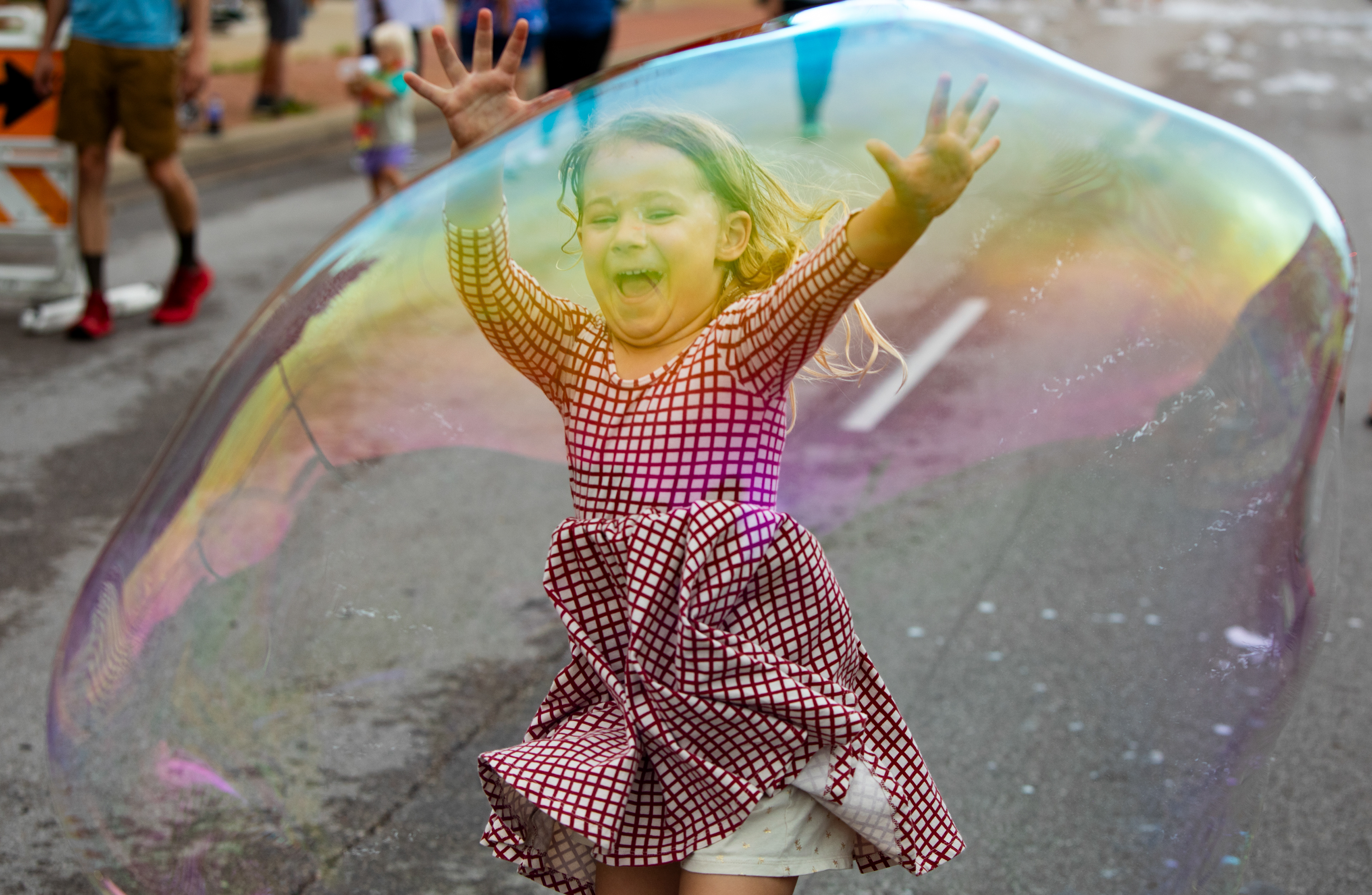 River Bubenik, 5, runs to pop a large bubble that was made by a member of the Bubble Bus during the Annual Ferguson Fourth of July Parade on Florissant Rd. in Ferguson, Mo. on Thursday, July 4, 2024. 