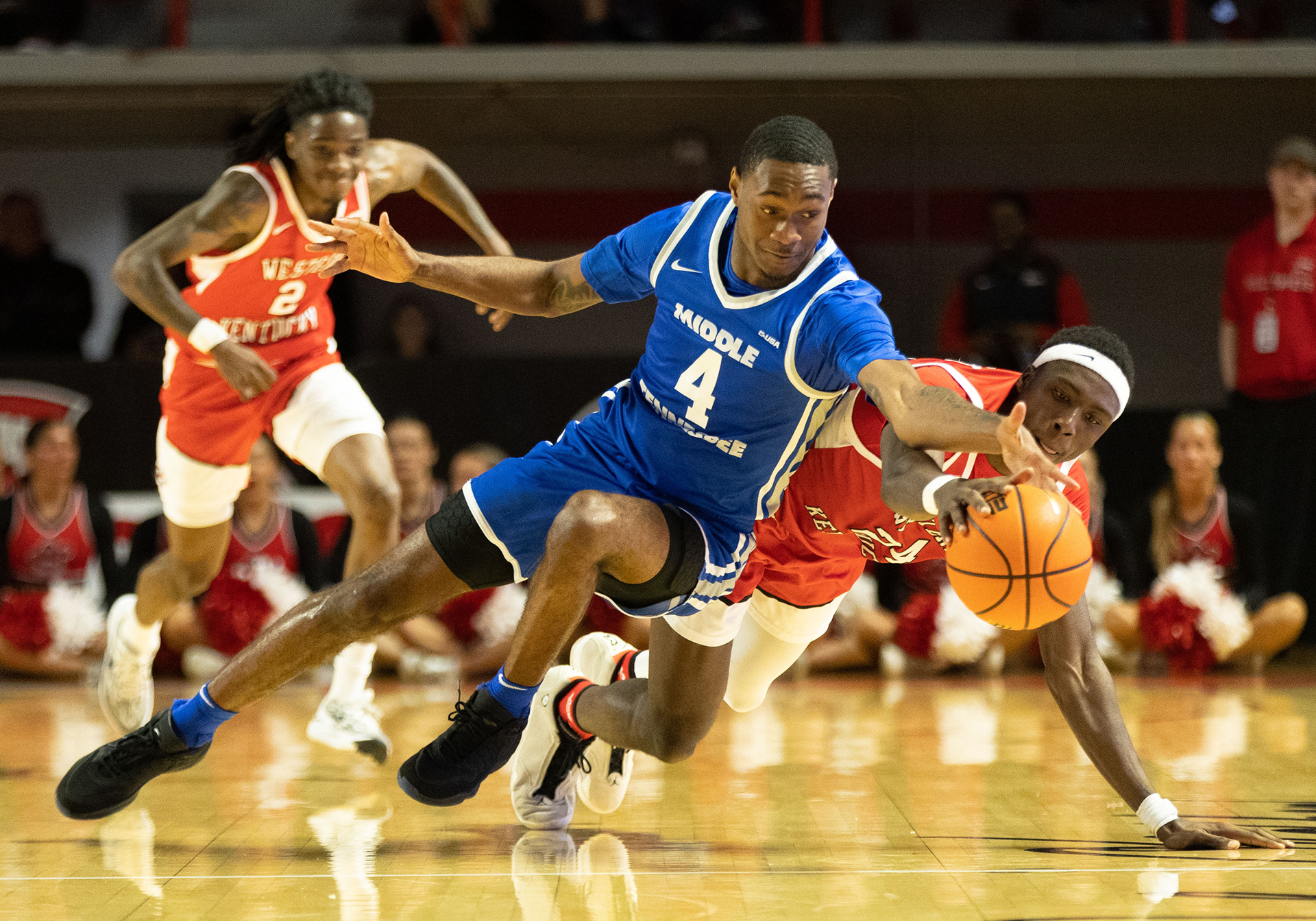 Middle Tennessee State University guard Justin Bufford (4) and Western Kentucky University forward Tyrone Marshall Jr. (24) dive for the ball during a game in the Diddle arena on Saturday, Feb. 3, 2024. 