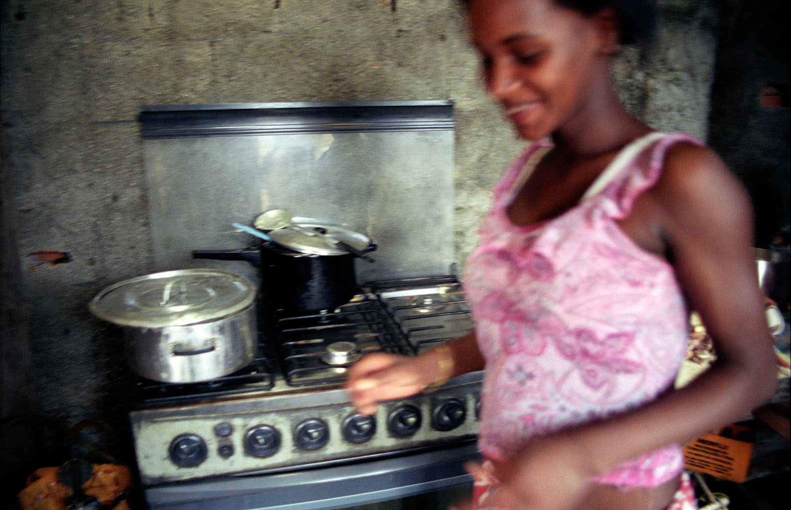 Woman cooking in her hut at the favela Terra Encantada, Rio de Janeiro, Brazil.