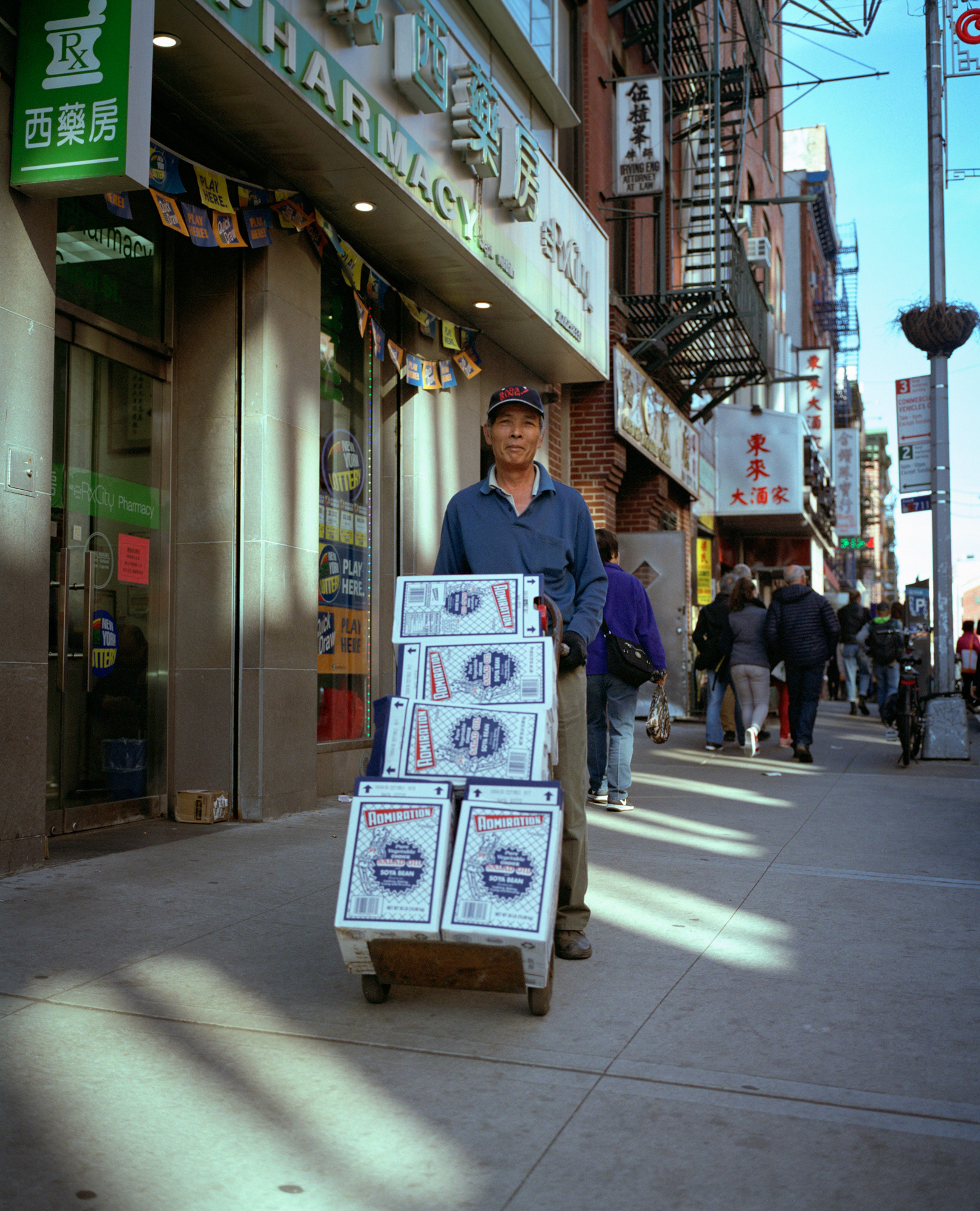 salad oil // a man pushes a cart filled of salad oil to his restaurant
