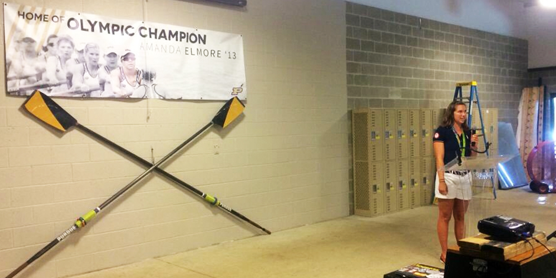 Home of Olympic Champion Amanda Elmore '13 Banner in Boathouse and Amanda Elmore presenting