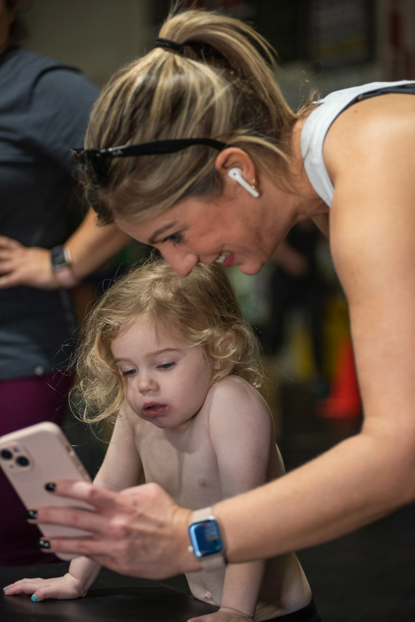 Holly Seckinger showing JoElaine Quirke, a photo of her dog before group class at CrossFit SEO, in Athens, Ohio, Nov. 10, 2023. CrossFit SEO is very welcoming and feels like family for everyone according to Seckinger. “My favorite part about SEO is how we all feel like a family, especially when Jolene brings in JoElaine ‘Joey’ she feels like my own daughter,” Seckinger said.
