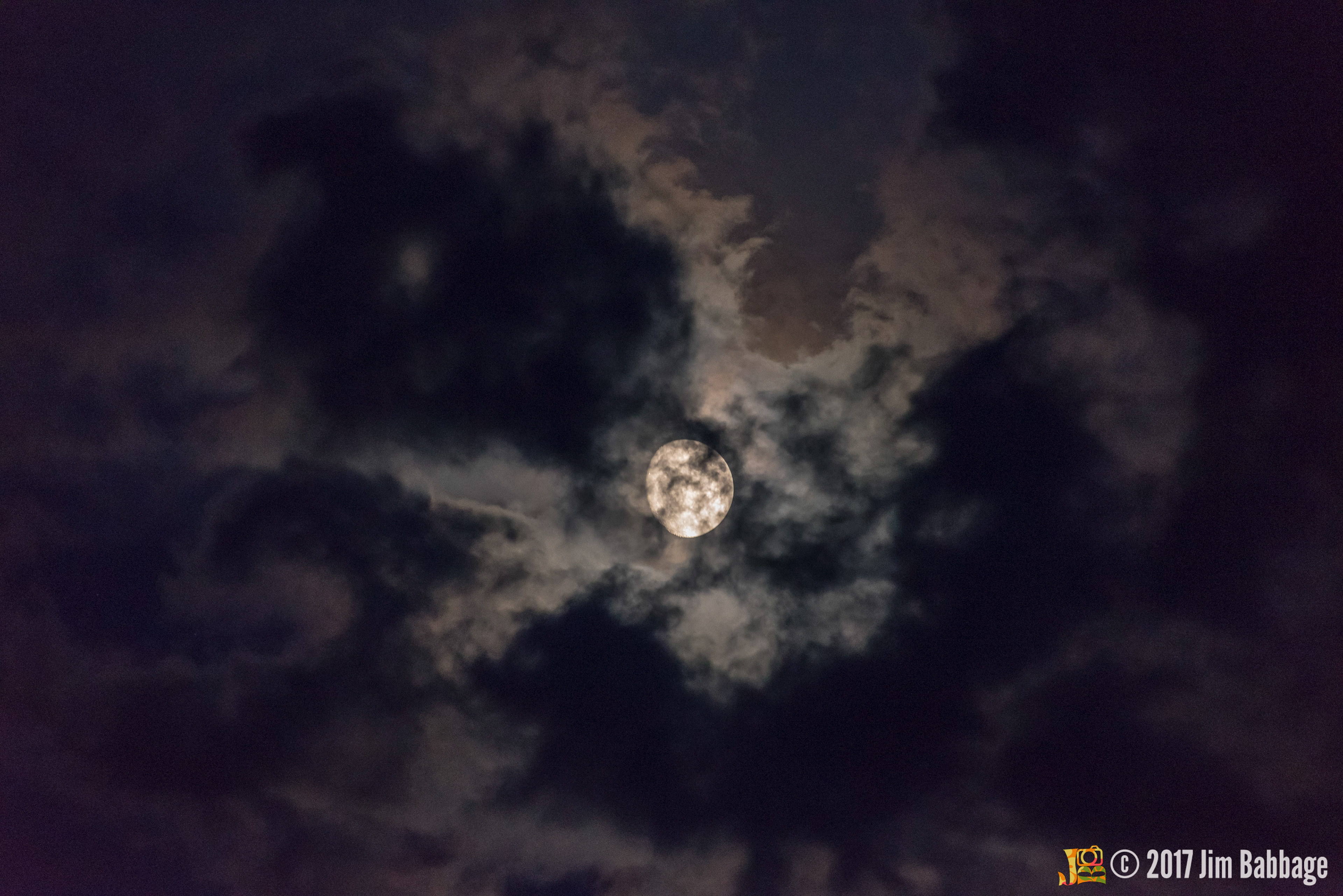Shot of the nearly full moon, partially obscured by clouds on Labour Day weekend