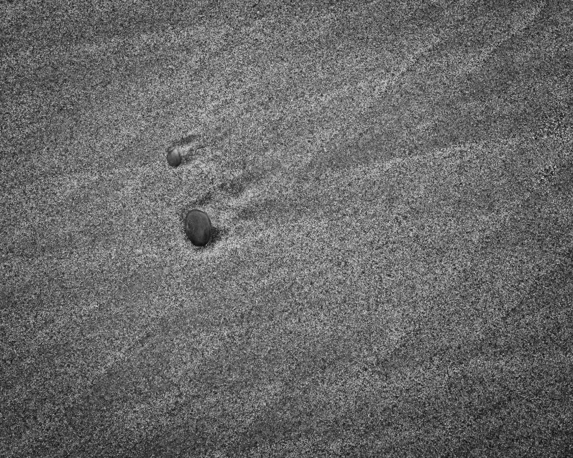 Two pebbles sit in a patch of sand that recorded the diamond pattern created when two lobes of a receeding wave met and crossed each other.  Don't meteors do something similar when they enter earth's atmosphere?  What about when people of different cultures meet and interact, do they set up something akin to interference patterns?