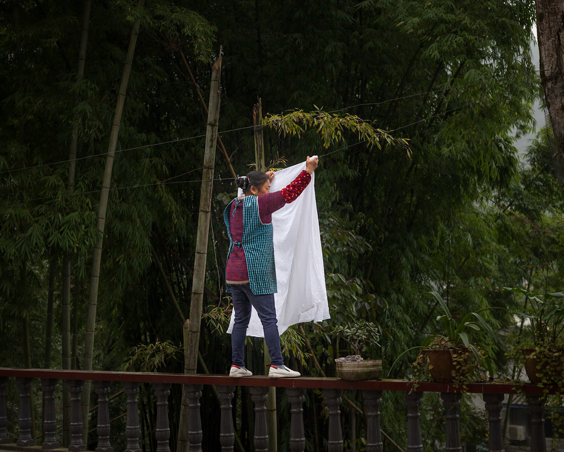 Woman hanging wahed sheets,  Emei shan, Sichuan, China
