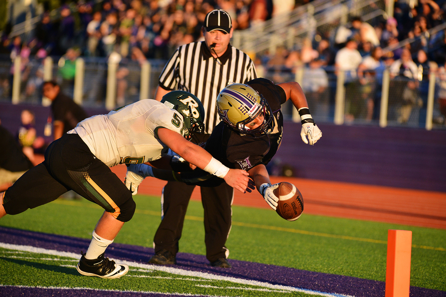 Hermiston's Costa Rodriguez dives for the end zone as Rex Putnam's Nick Edwards attempts to stop the drive Friday, Aug. 30, 2013, in the Bulldogs' 20-14 win against the Kingsmen in Hermiston, Oregon.