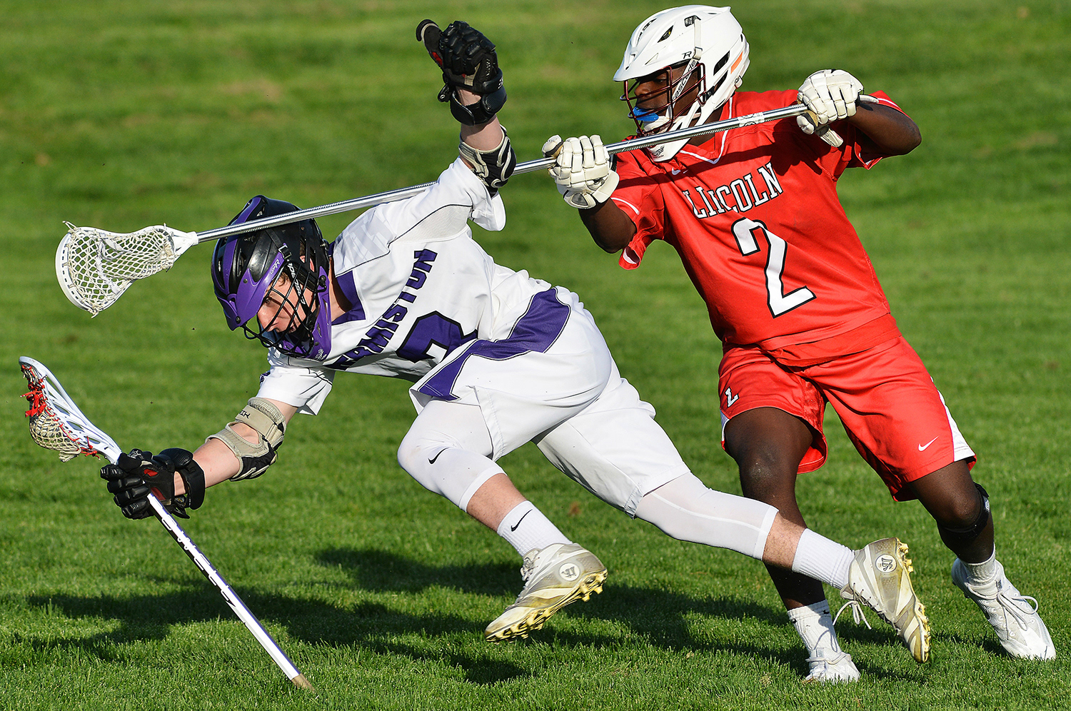 Hermiston's Chris Jones takes a hit from Lincoln defender Zenzo Beresford in the Bulldogs' 15-1 loss to the Cardinal on Friday, April 8, 2016, in Hermiston.