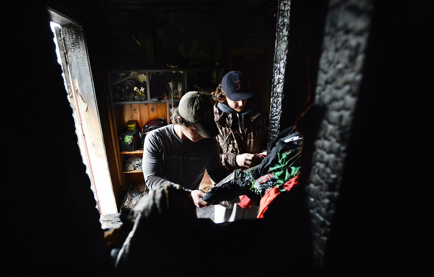 Brothers Nick and Andy McFarlane looked through damaged clothing that was in a closet in a burned-out section of their home at 401 Northwest Sixth Street on Wednesday, Jan. 30, 2013, in Pendleton, Oregon.