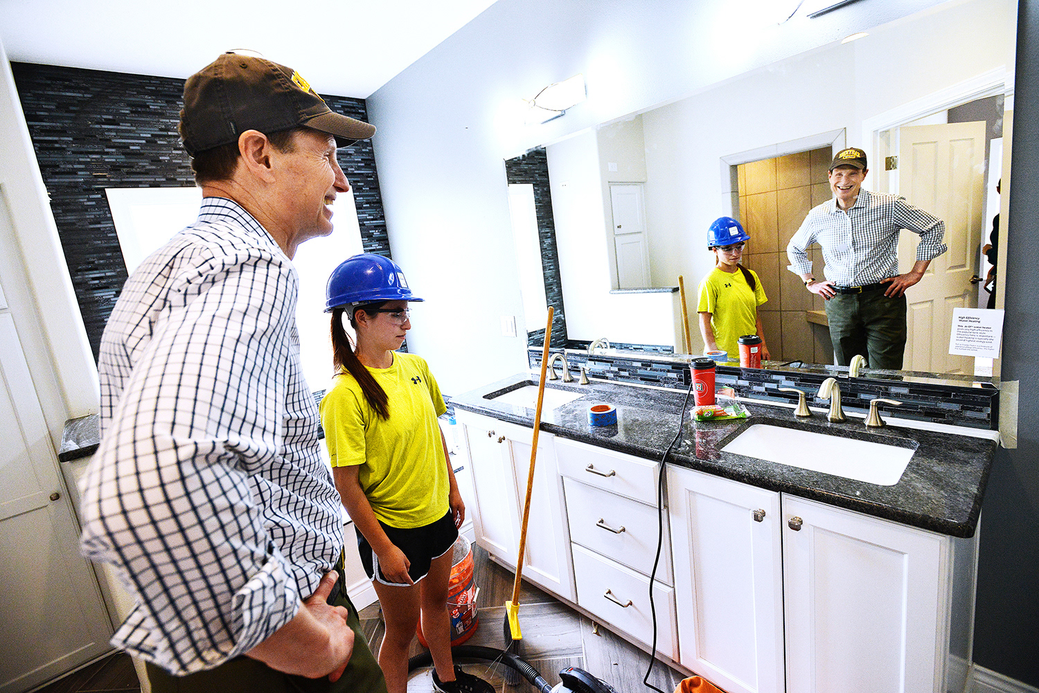 Sen. Ron Wyden, D-Ore., smiles at himself in the mirror of a bathroom while on a tour with Hermiston senior Elizabeth Herrera of the second house built by students for the Columbia Basin Student Homebuilding Program on Wednesday, June 1, 2016, in Hermiston, Oregon.