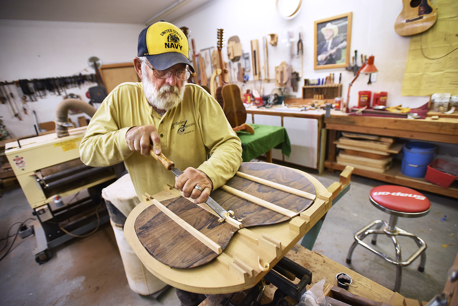 Les McMasters of Hermiston uses a carving chisel to shape the braces on the back a guitar at his shop Friday, Nov. 30, 2018, in Hermiston. McMasters hand makes guitars often using locally sourced materials for his projects.