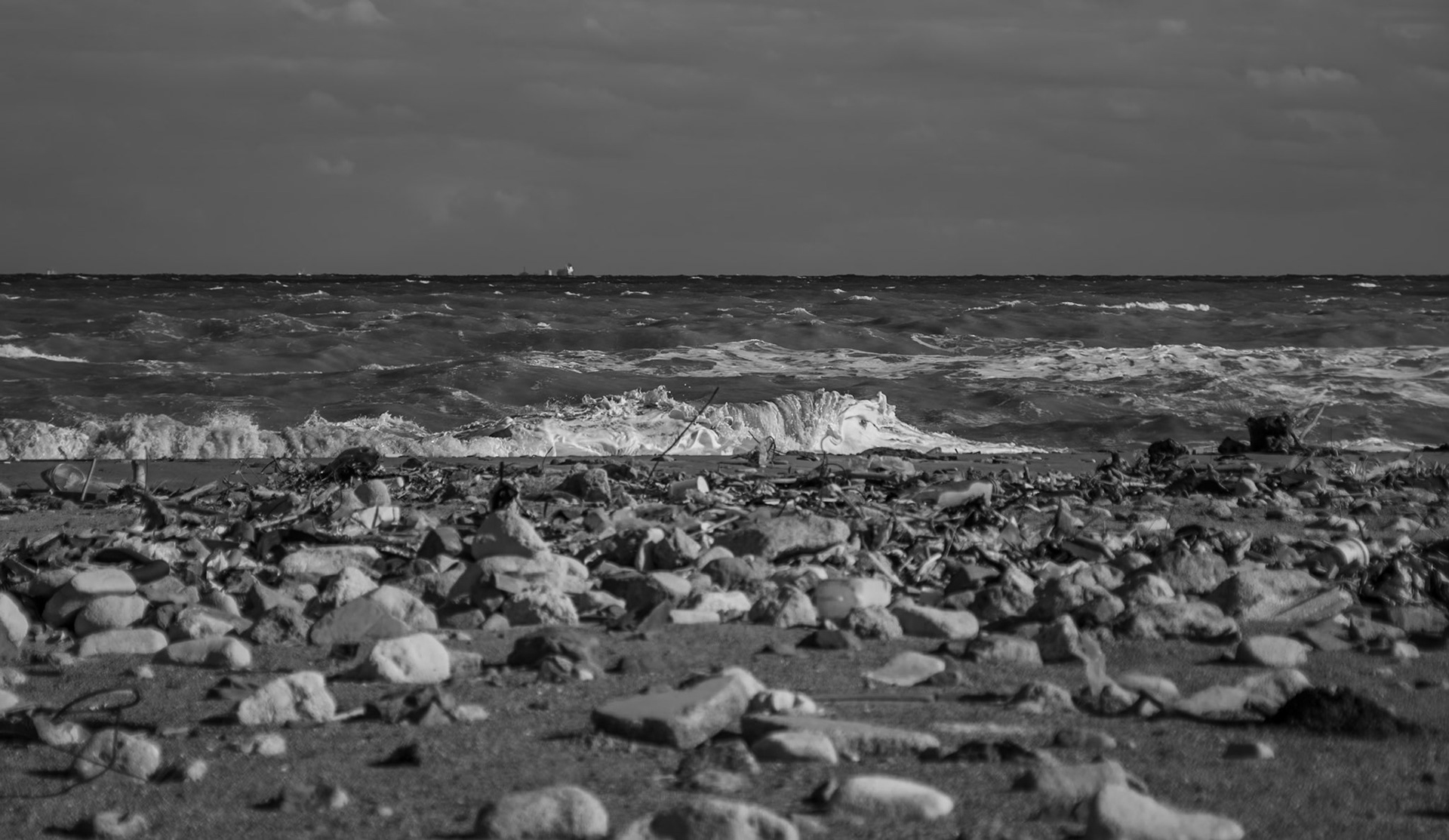 Black Sea coast east of Yeniköy: flotsam, stones, sea and a ship