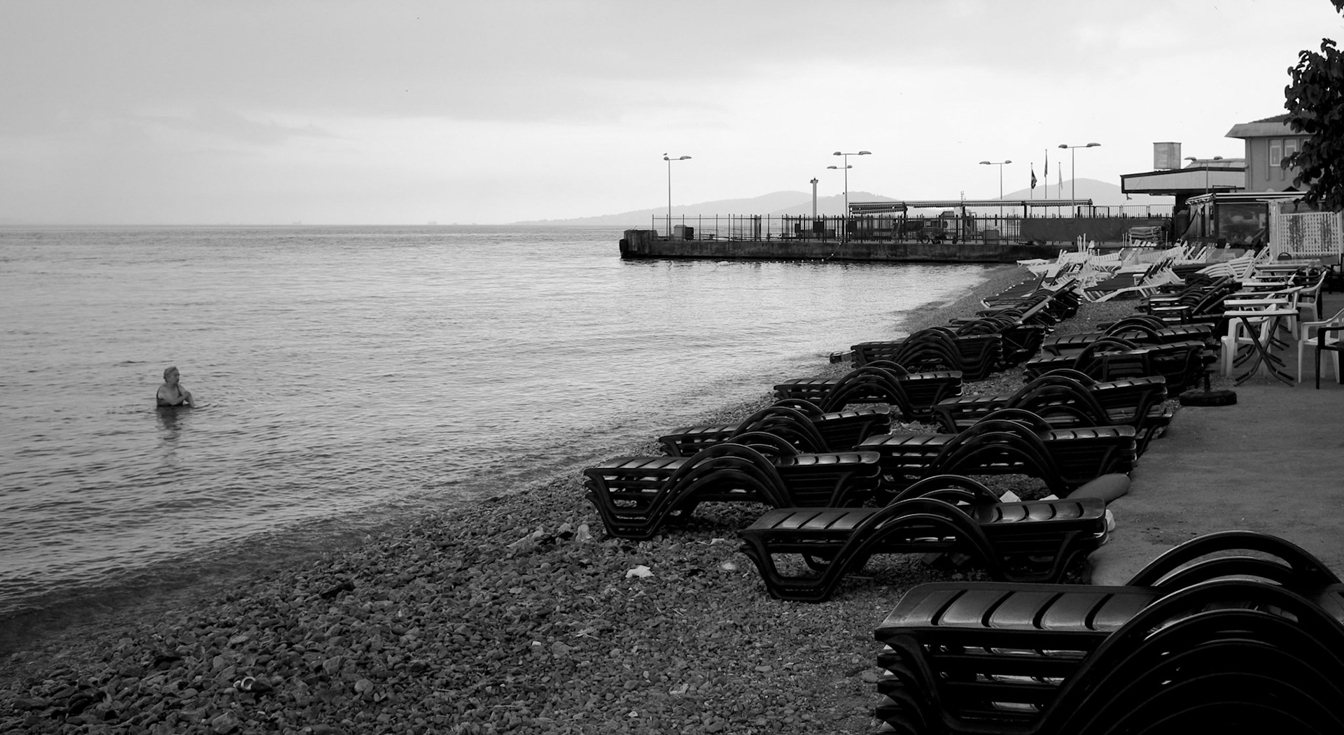 Kınalıada: empty beach by the boat station with a few early morning dippers