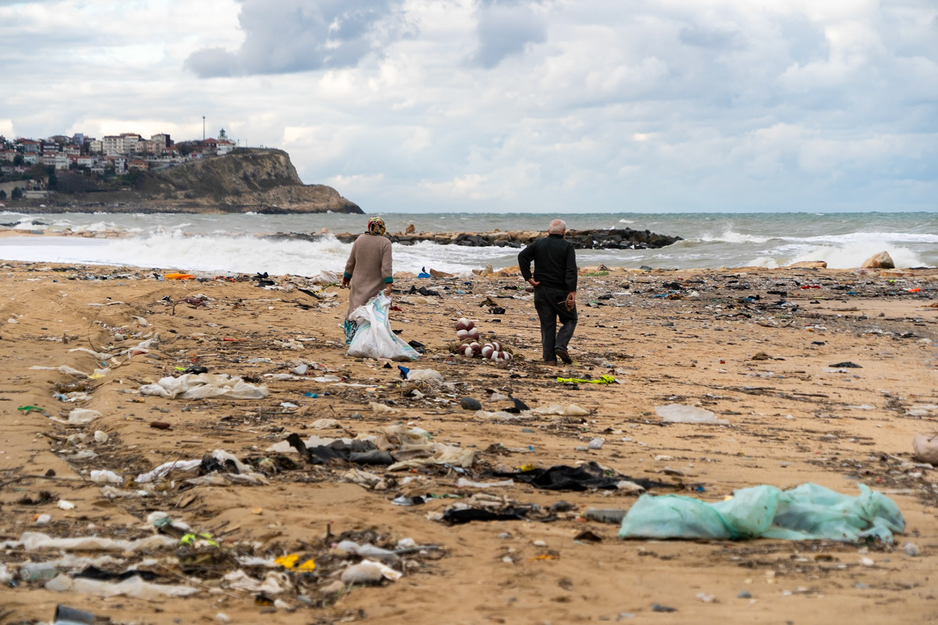 Karaburun beach: a friendly, elderly couple collecting driftwood for their home fire