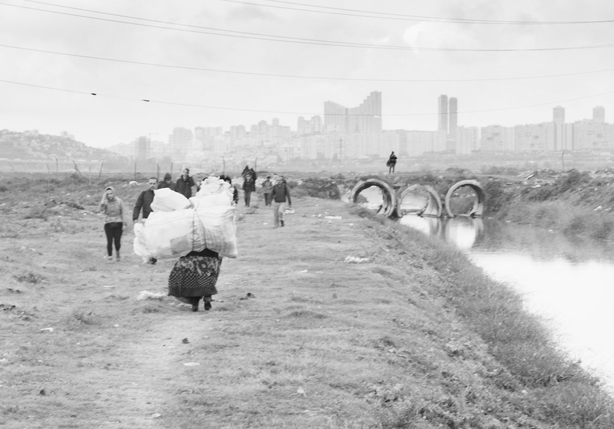 between Istanbul University's veterinary farm and the agricultural faculty: after crossing the pipe-bridge, looking north along the Hadımdere towards Bahçeşehir; a woman is carrying a large load