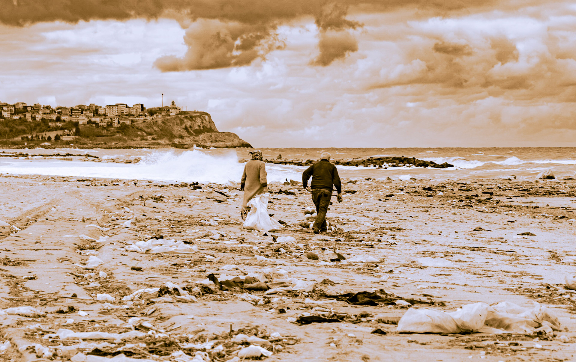 Karaburun beach: a friendly, elderly couple collecting driftwood for their home fire
