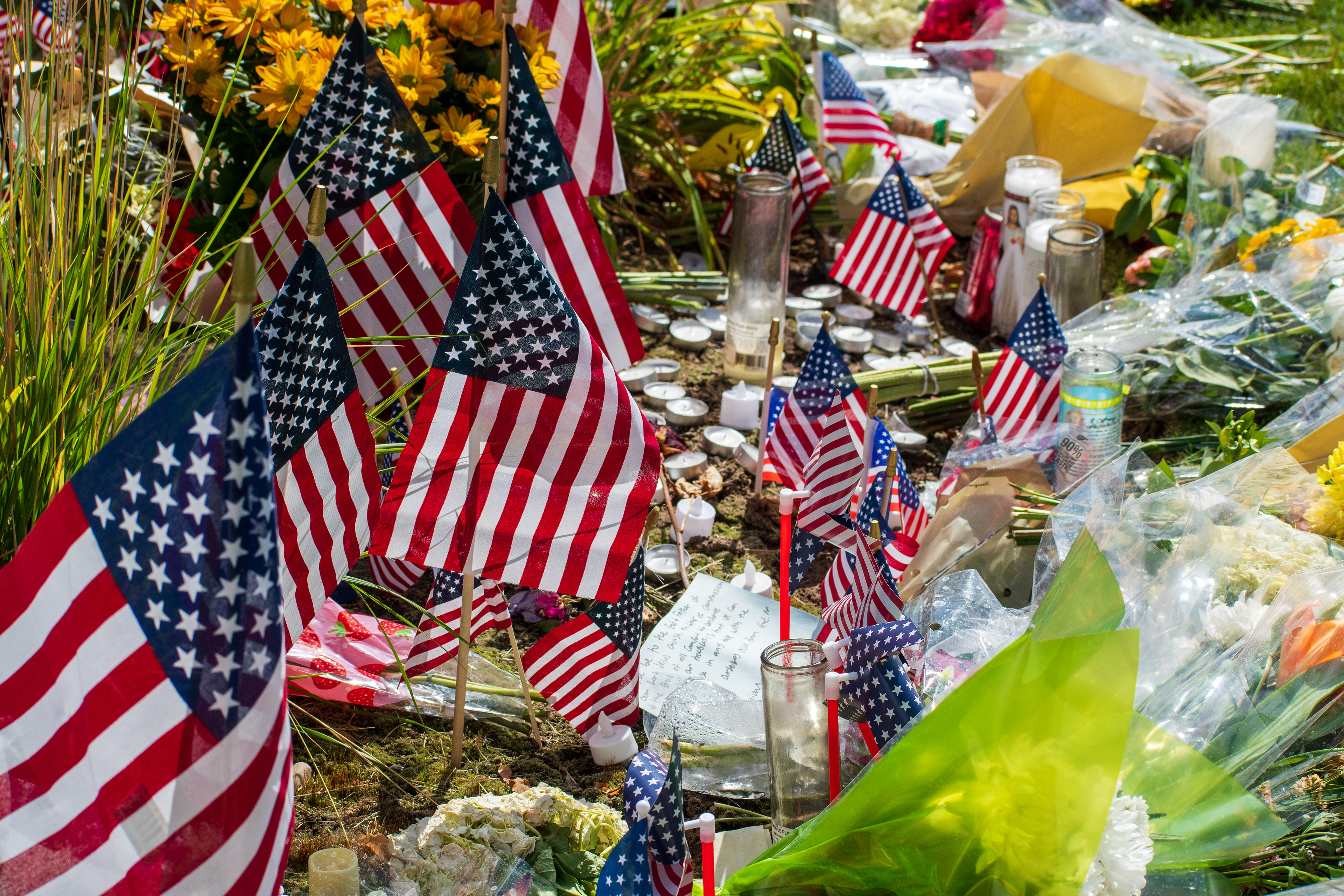 OREM, UTAH – SEPTEMBER 12, 2025: American flags, flowers, candles, and personal tributes are arranged at a memorial site for Charlie Kirk outside Timpanogos Regional Hospital. The display includes patriotic symbols and decorative items placed on the grass near the roadside. © Charles‑McClintock Wilson / ZUMA Press
