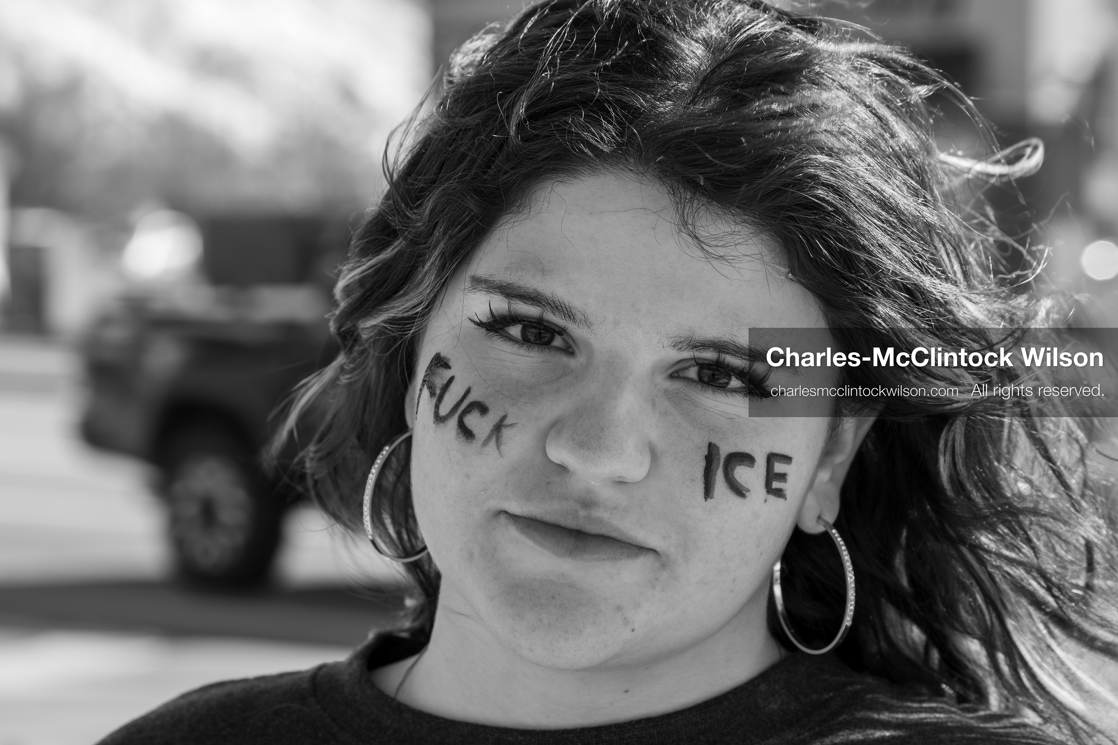 February 20, 2026, Orem, Utah, USA: A participant with protest text written on her face stands near other demonstrators during a student led protest against ICE in front of Orem City Hall. The group gathers along State Street as the event continues. (Credit Image: © Charles McClintock Wilson/ZUMA Press Wire)
