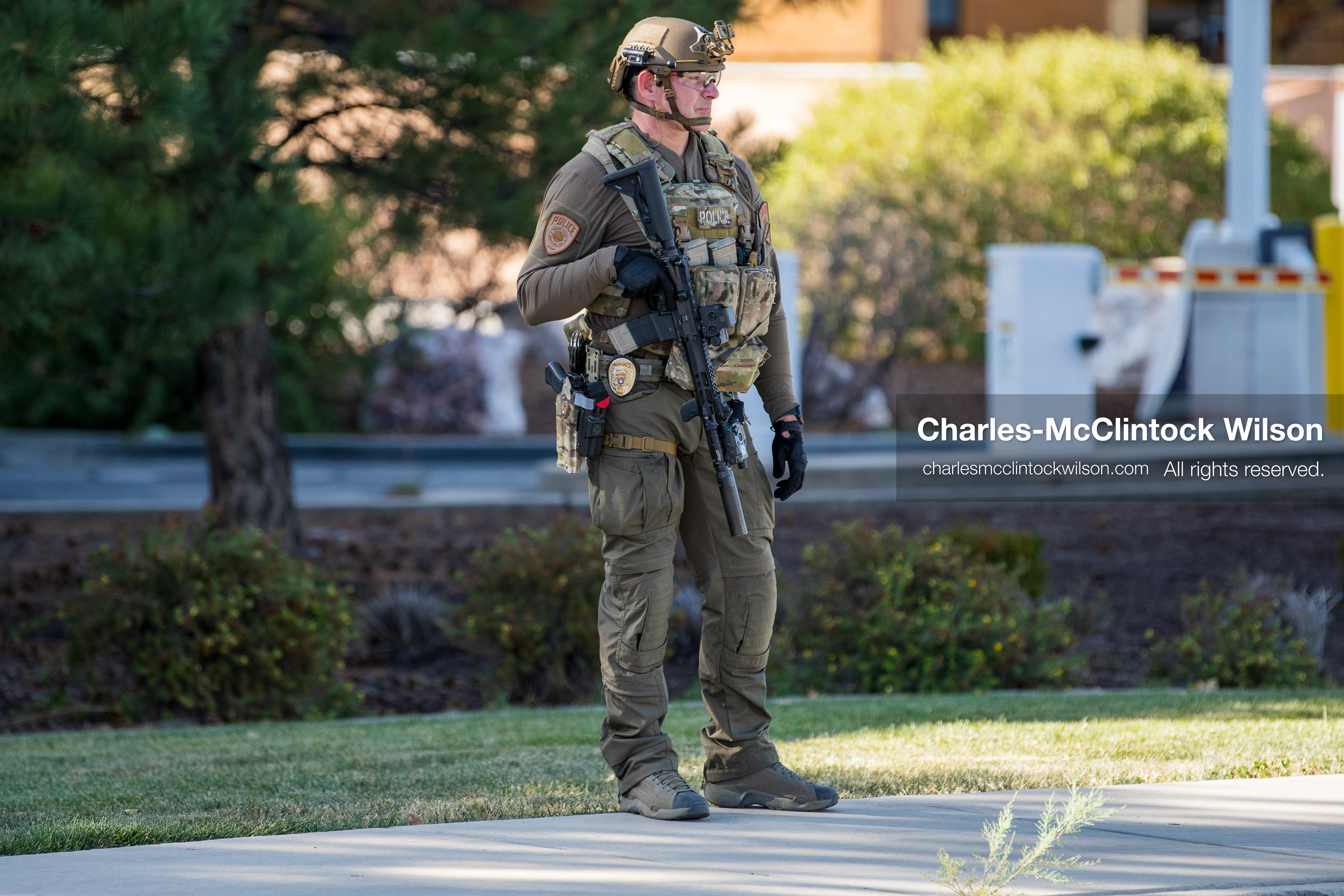 An armed law enforcement officer wearing a helmet and tactical gear stands guard outside Intermountain Medical Center in Murray, Utah, on Monday, August 17, 2026. Multiple regional law enforcement agencies converged to heavily secure the hospital perimeter as a safety precaution after shooting victims arrived from a fatal shootout that erupted outside a funeral service in nearby Kearns earlier that day. (Photo by Charles-McClintock Wilson/Sipa USA)