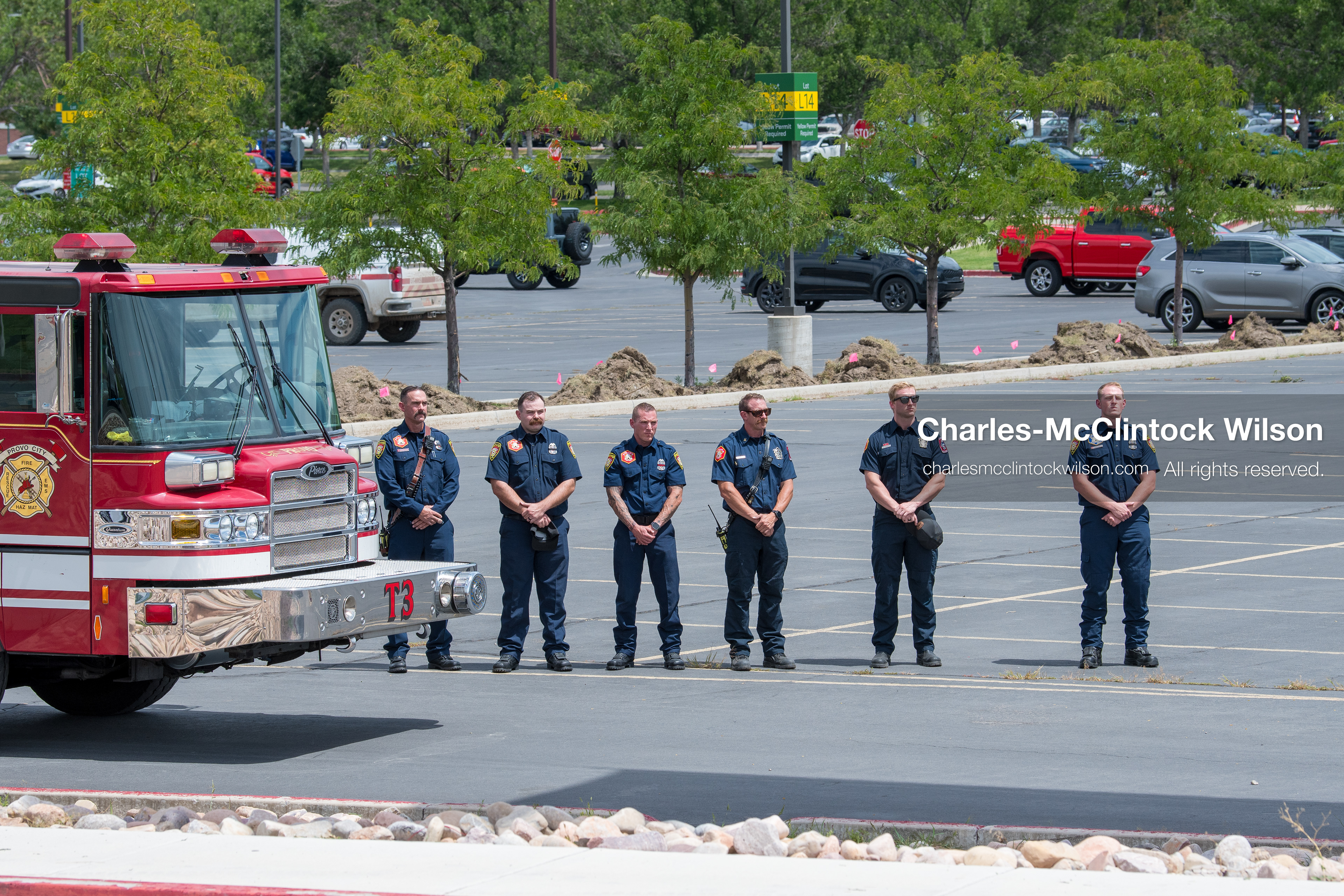 A group of firefighters stands at attention in a row next to a parked fire engine outside the UCCU Center at Utah Valley University in Orem, Utah, on Wednesday, July 29, 2026. More than 300 people came to the public memorial ceremony to honor Provo Fire Captain Spencer Long, his wife Katrina, and three of their sons, who died after a flash flood hit their campsite near the Sunglow Campground in Wayne County. (Photo by Charles-McClintock Wilson/Sipa USA)