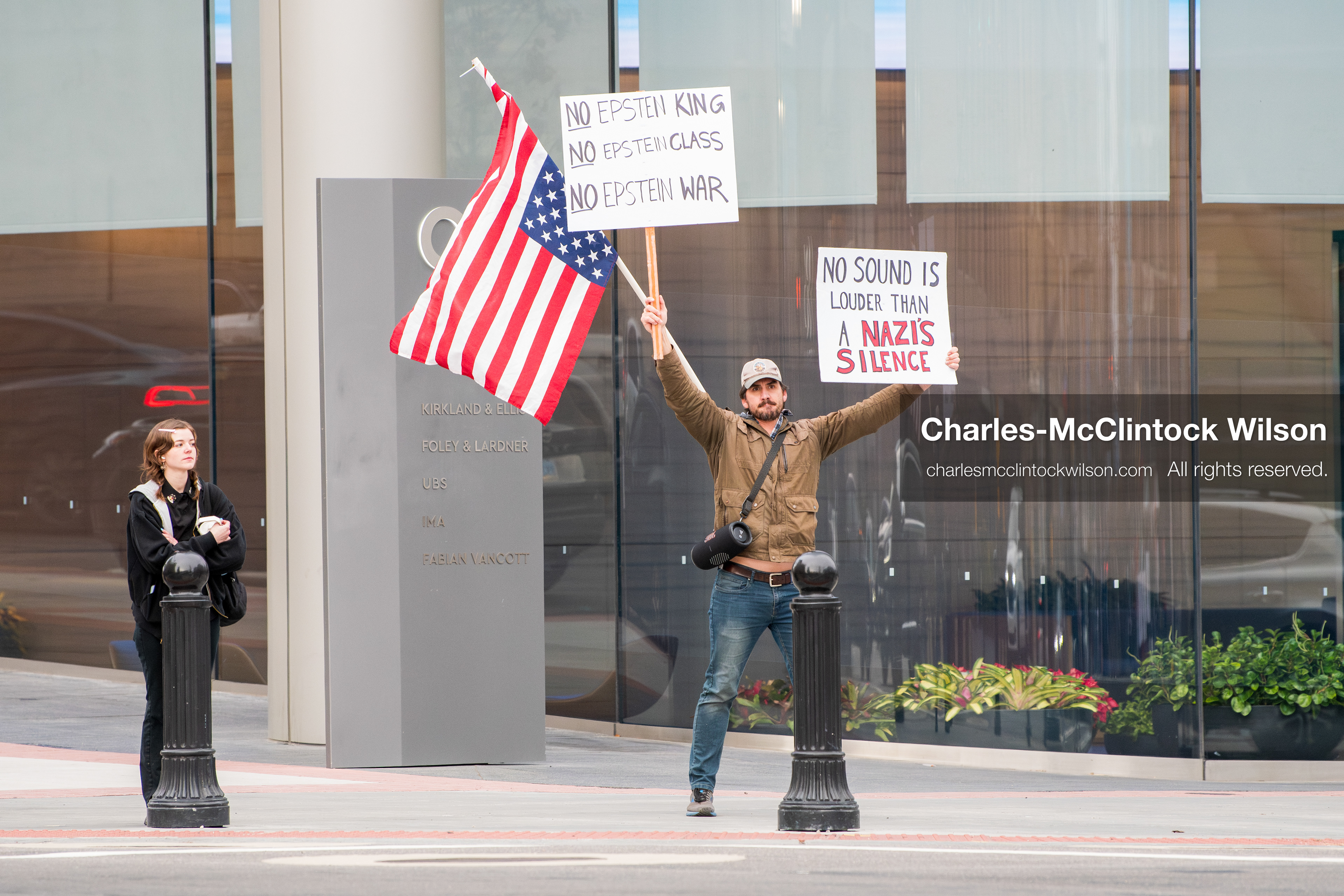 January 3, 2026, Salt Lake City, Utah, USA: A protester holds signs and an American flag during a demonstration against US action in Venezuela outside the Wallace Federal Building in Salt Lake City, Utah. The protest was part of a nationwide mobilization responding to recent military developments. (Credit Image: (c) Charles‑McClintock Wilson/ZUMA Press Wire)