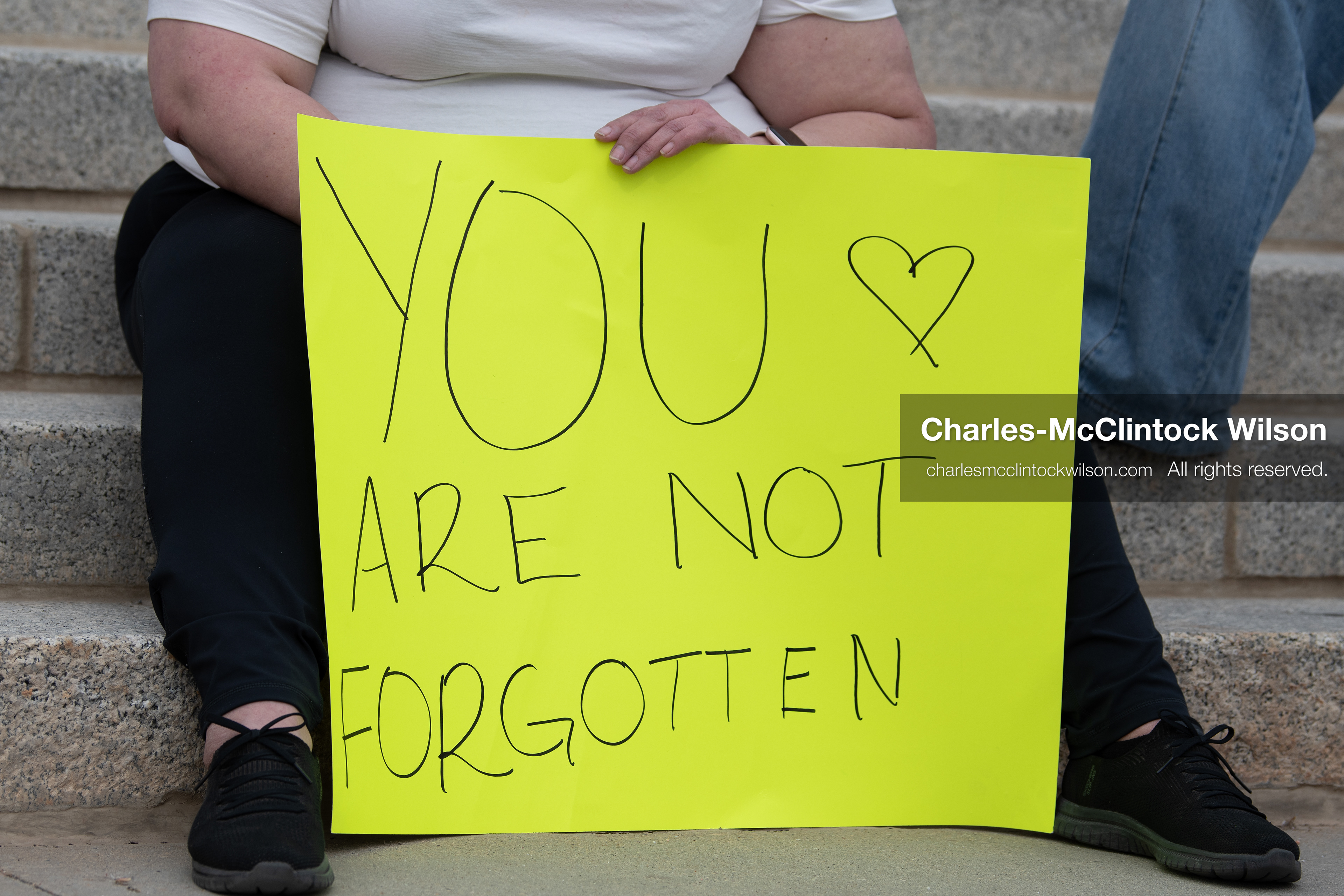 February 28, 2026, Salt Lake City, Utah, USA: A demonstrator sits on the steps near the Utah State Capitol holding a yellow sign reading You Are Not Forgotten during the Stand With Ukraine rally. The gathering marked the four year anniversary of the full scale Russian invasion of Ukraine and brought community members together in support of Ukrainians and local humanitarian efforts. (Credit Image: © Charles McClintock Wilson/ZUMA Press Wire)