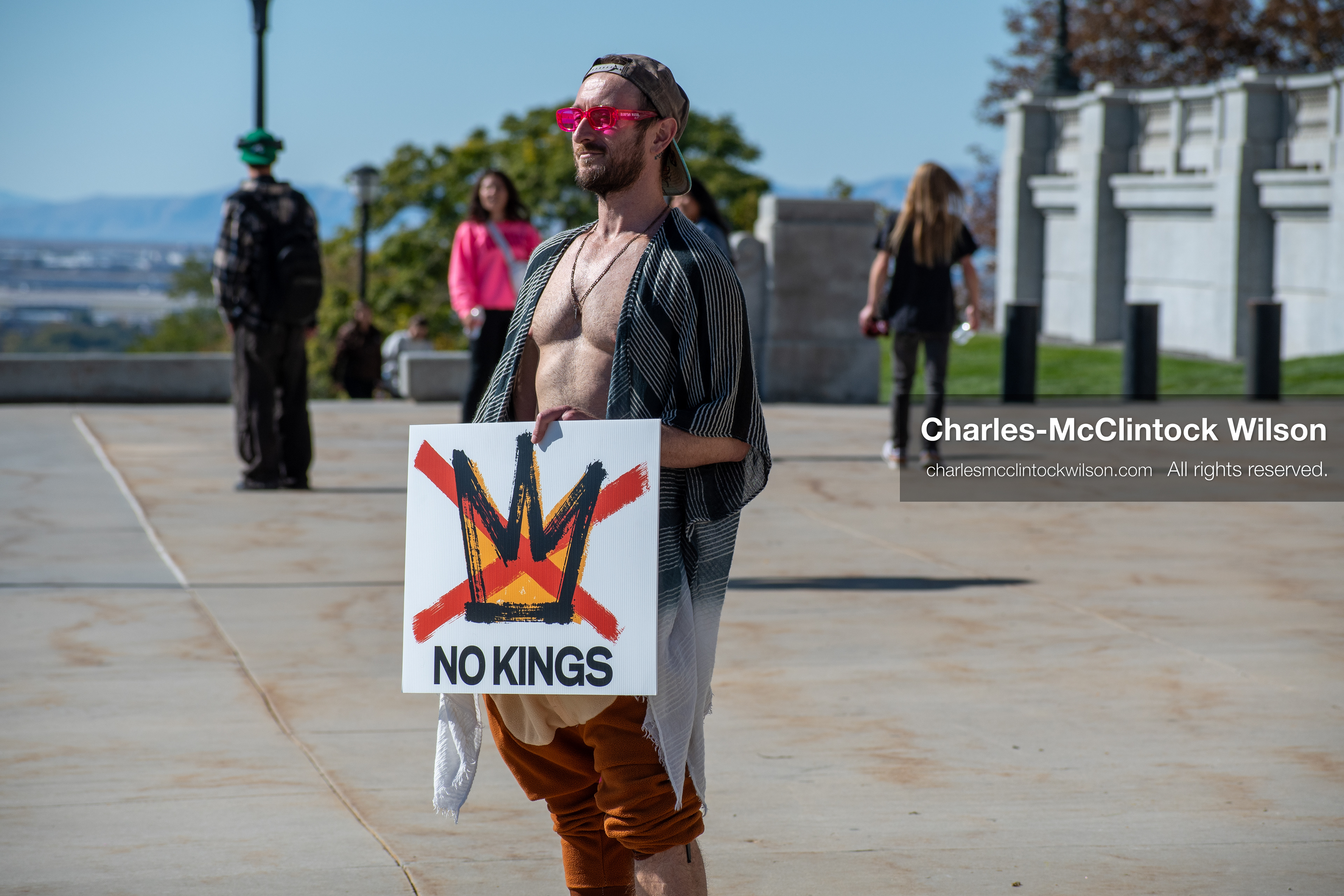 October 18, 2025, Salt Lake City, Utah, USA: A demonstrator holds a sign featuring a crossed-out crown and the phrase "No Kings" during a protest outside a government building in Salt Lake City, Utah. The protest was part of a nationwide mobilization.