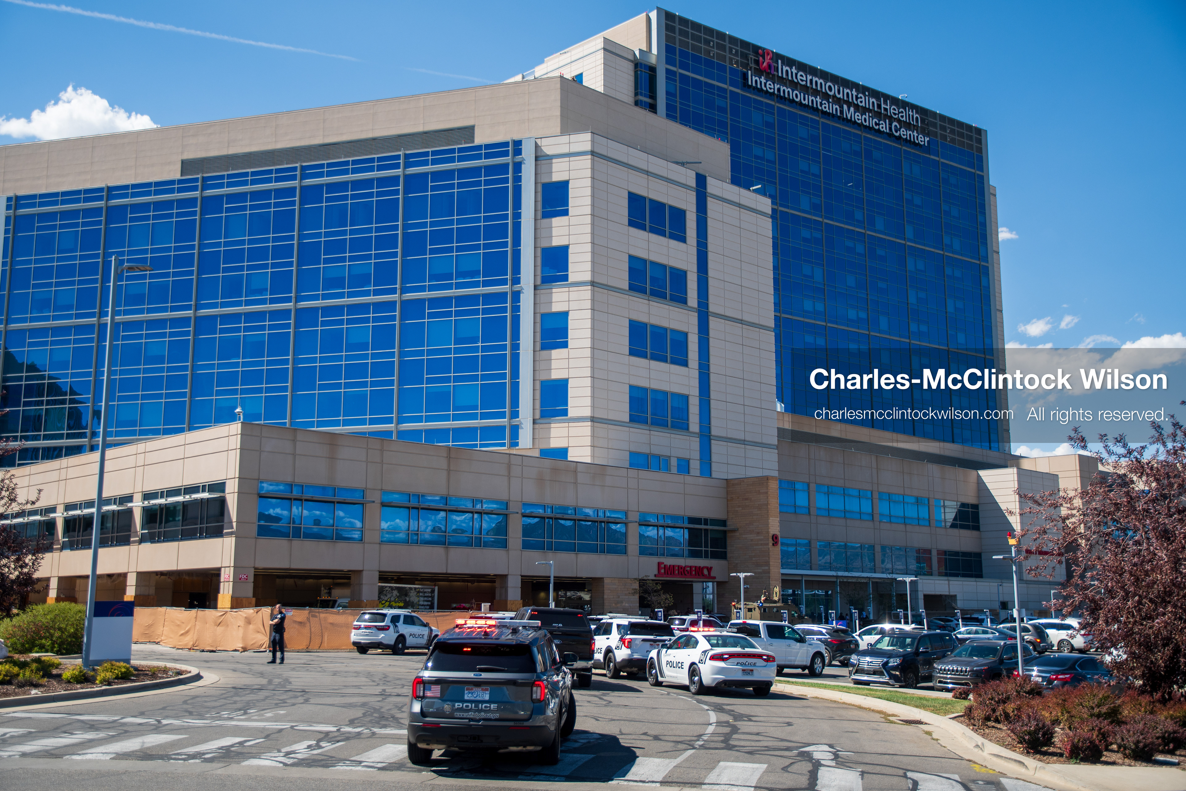A wide view shows the exterior building facade and parking area of Intermountain Medical Center in Murray, Utah, United States, on August 17, 2026. Multiple regional police agencies secure the hospital perimeter as a safety precaution after shooting victims were admitted following a fatal shootout outside a funeral service in nearby Kearns. (Photo by Charles-McClintock Wilson/NurPhoto)